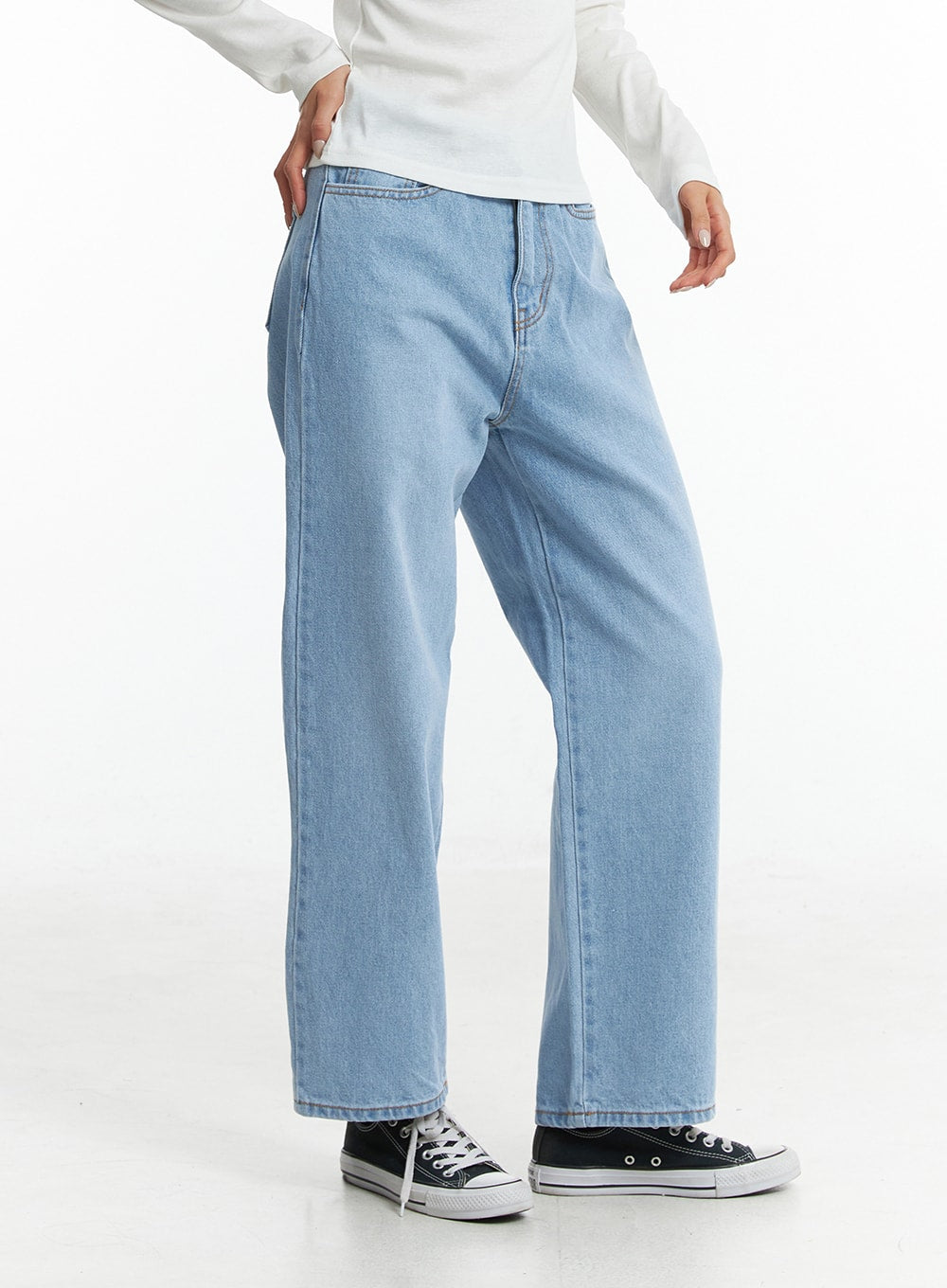 Light Washed Straight Jeans ON329 in light blue, side-angle lower-body shot on model, straight leg silhouette with clean seam line, paired with white long-sleeve top and black sneakers.