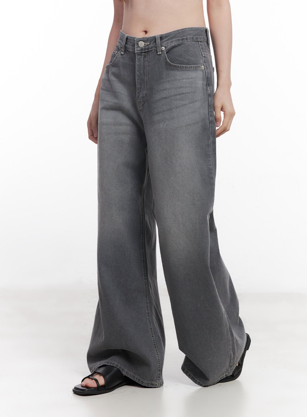 Beatriz Washed Wide-Leg Jeans CY519 in gray, side-angle waist-down shot on model, wide-fit washed denim with faded wash, floor-grazing hem, black sandals.