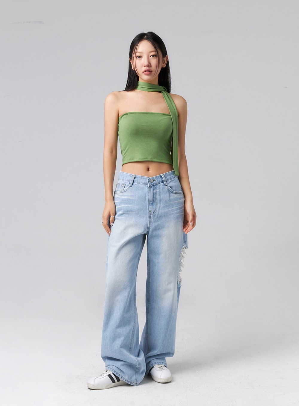 Ripped Side Jeans CL320 in light blue, full-body front shot on model standing straight, wide-fit washed denim with side rip detail, styled with green halter crop top and white sneakers.