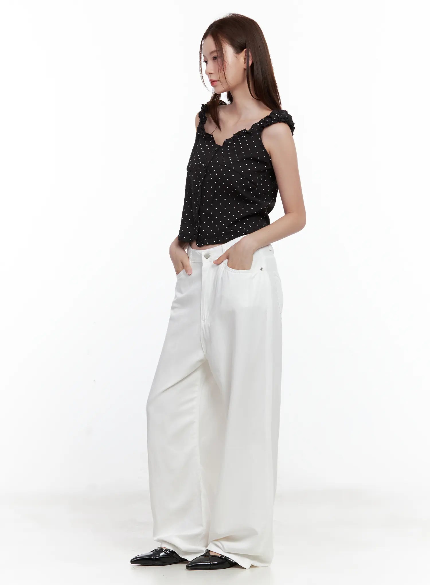 Jennie Baggy Wide-Leg Jeans CL502 in white, side view on model, hands in front pockets, relaxed baggy wide-leg cotton cut, paired with black polka-dot cami and black mules.