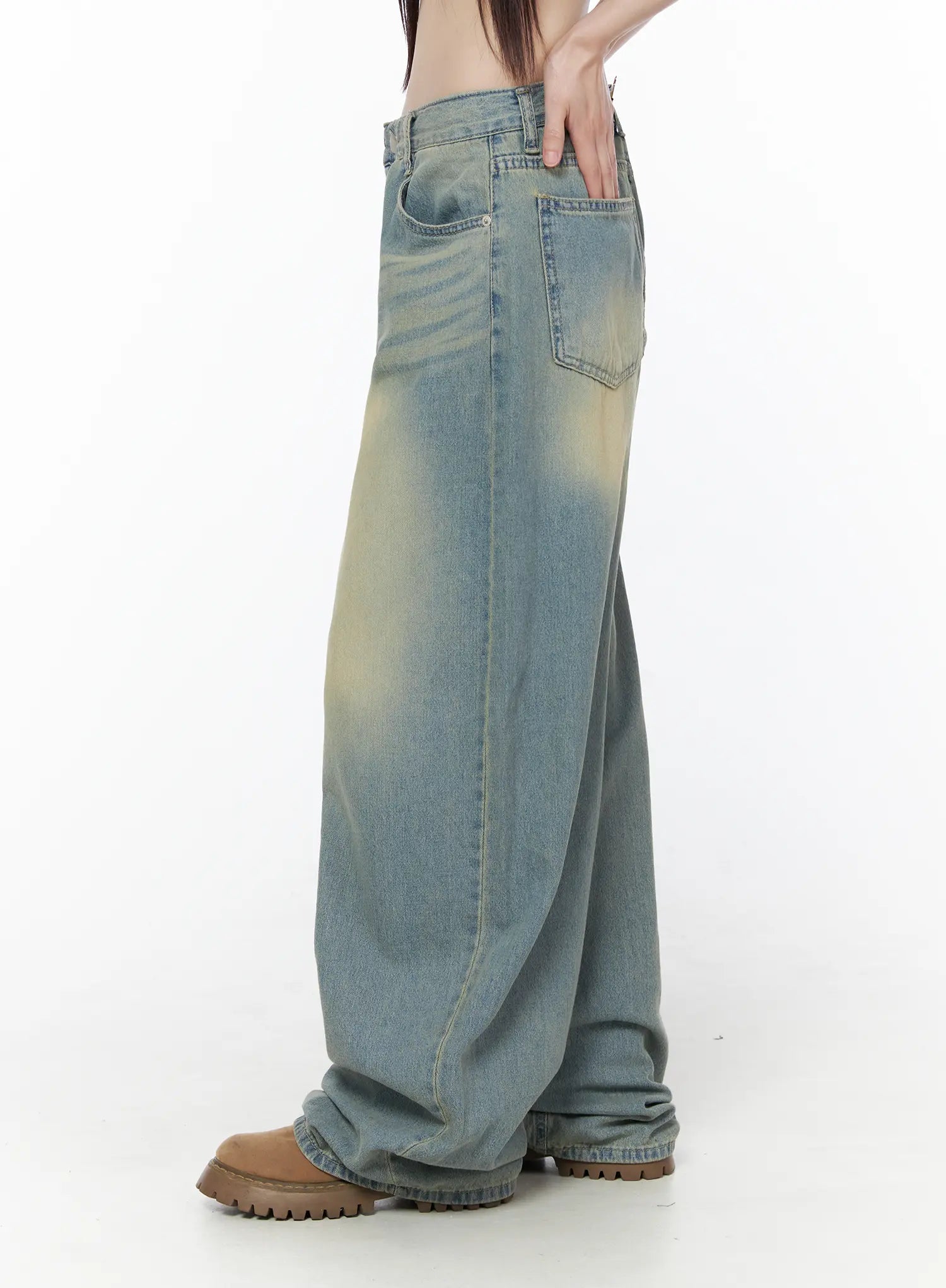 Rain Vintage Washed Wide Leg Jeans CU519 in light blue, side view on model, ultra-wide leg with yellow sun-faded panels, back pocket visible, excess denim pooling over chunky boots.