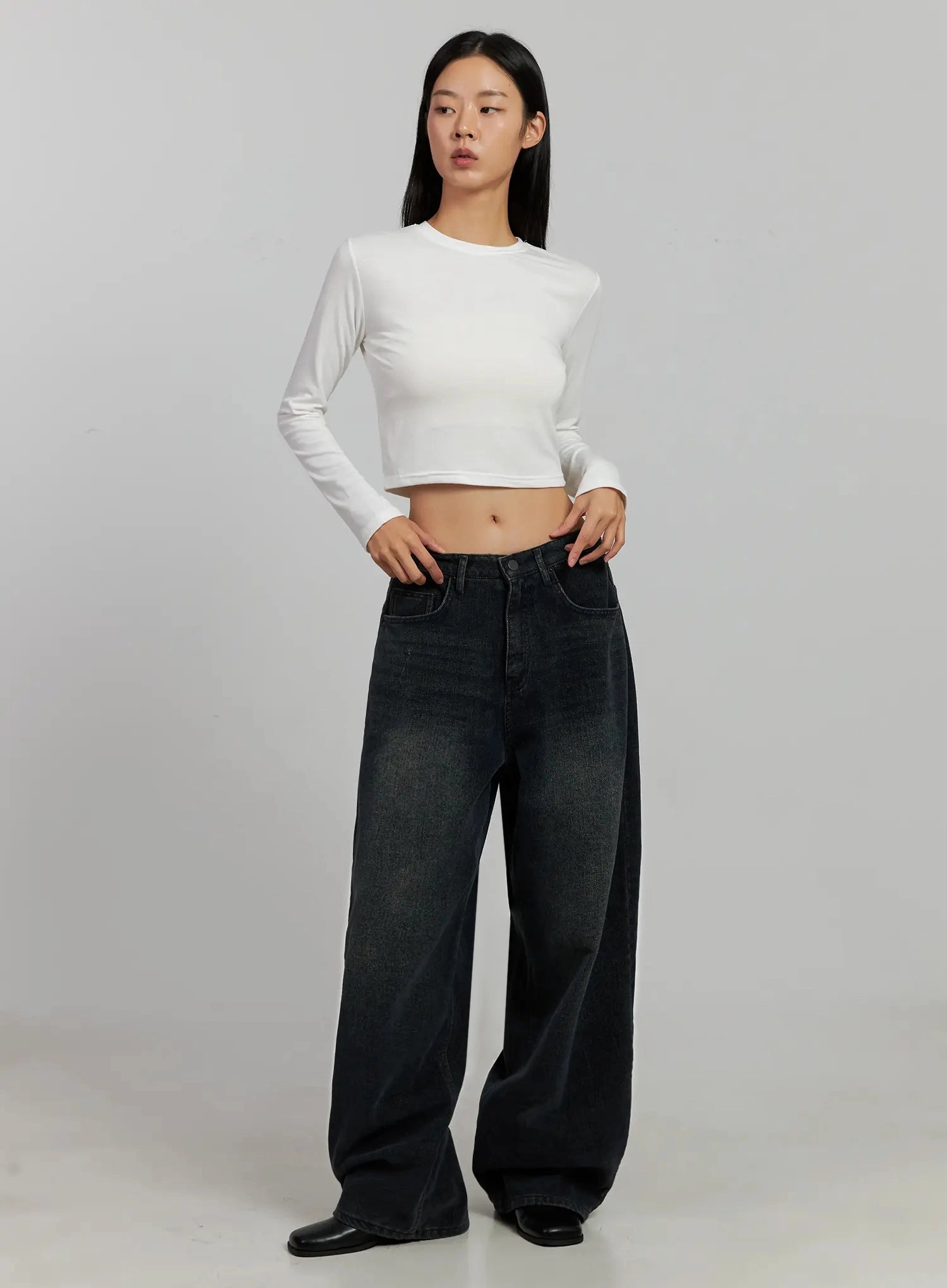 Aubree Washed Wide Jeans IJ502 in dark blue, three-quarter front view on model, wide-leg low-rise washed cotton denim paired with white cropped long-sleeve top and black mules.