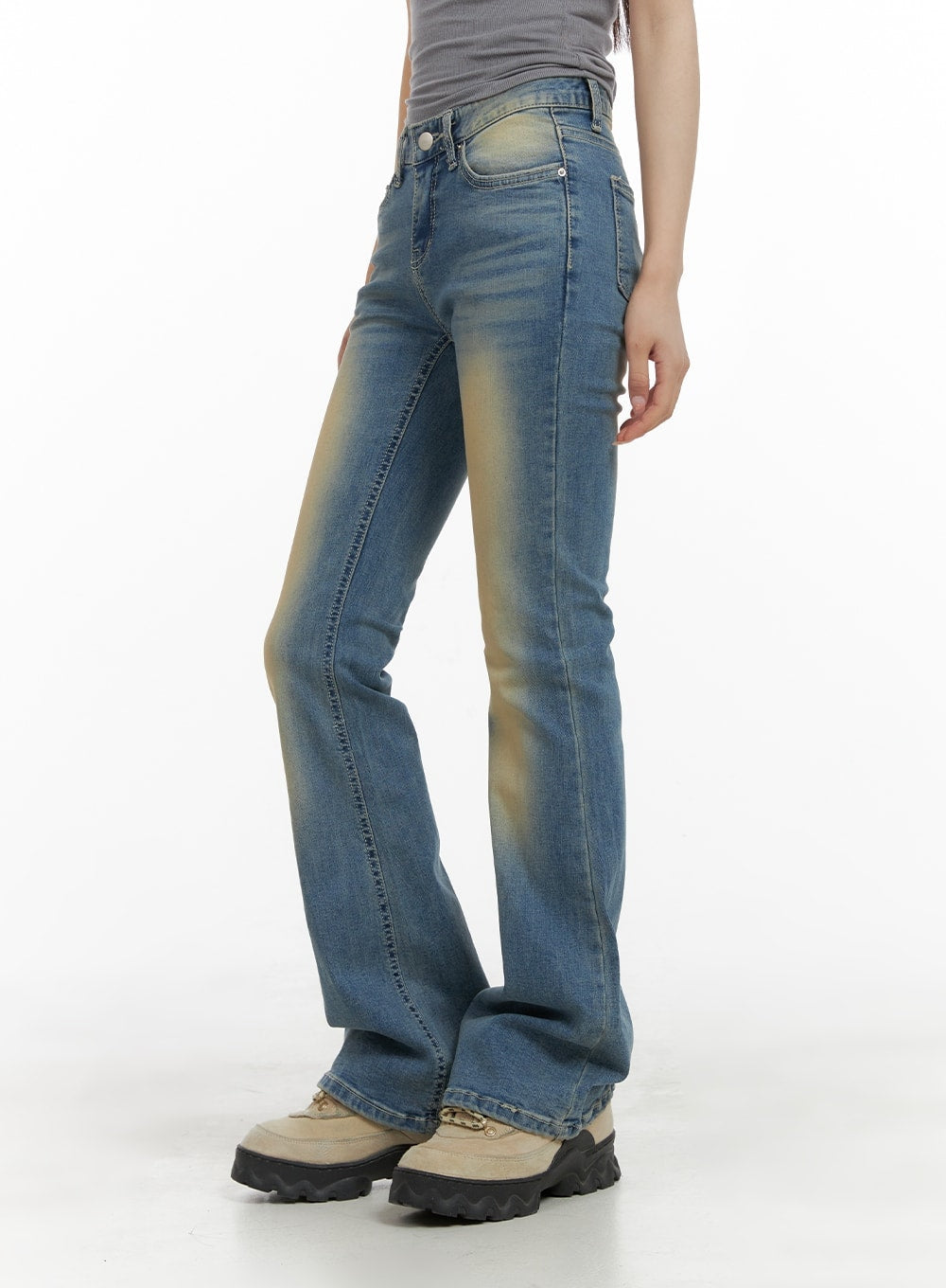 Slim Fit Washed Bootcut Jeans CA402 in blue, side view on model, slim fit with subtle bootcut flare, visible washed yellow fading along thigh and seam, worn with chunky lug-sole boots.