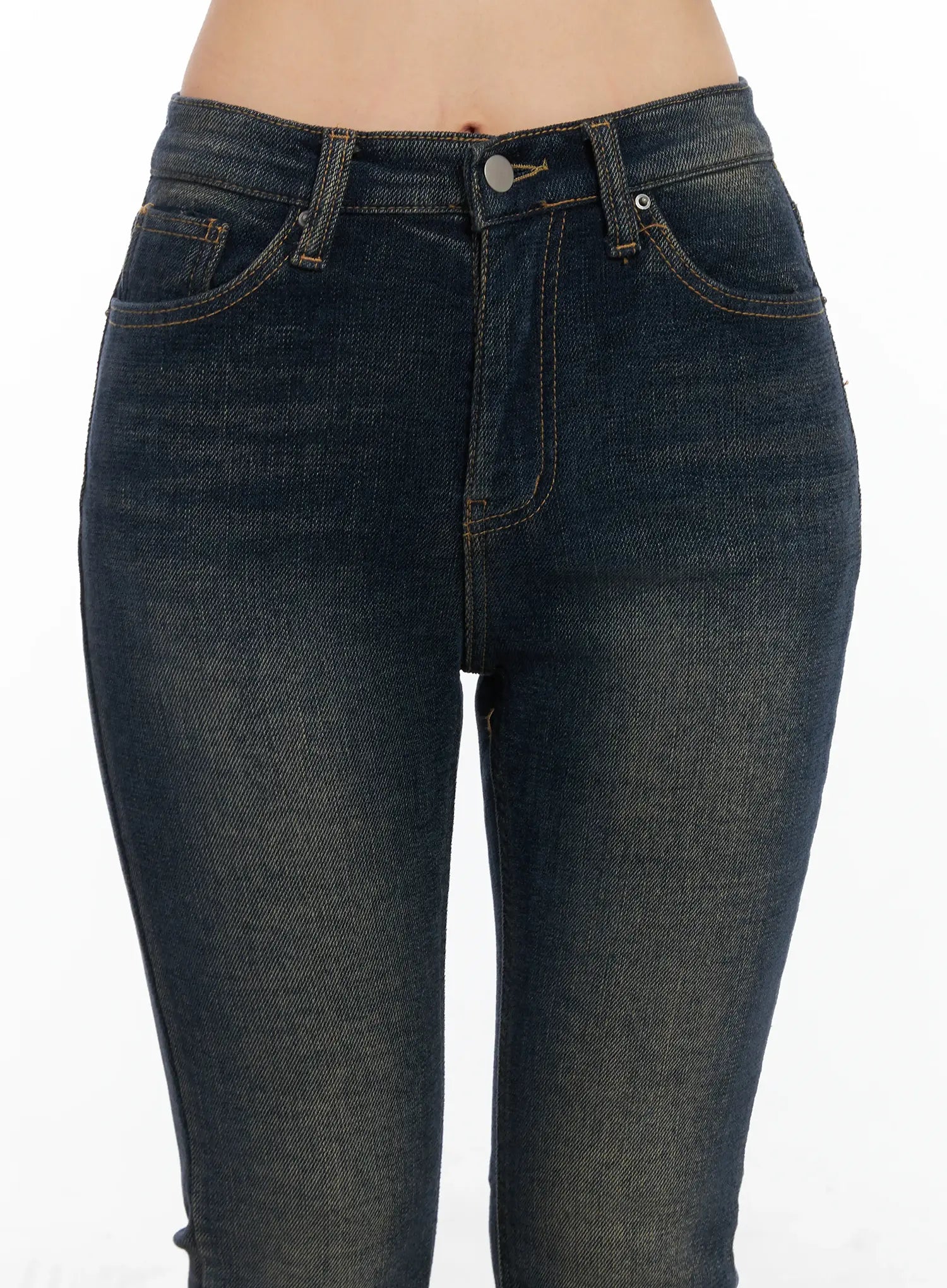 Jordyn High-Waist Bootcut Jeans CD502 in dark washed indigo, front waist close-up on model, high-rise fit with five-pocket design, contrast topstitching, and button-fly detail on washed denim.
