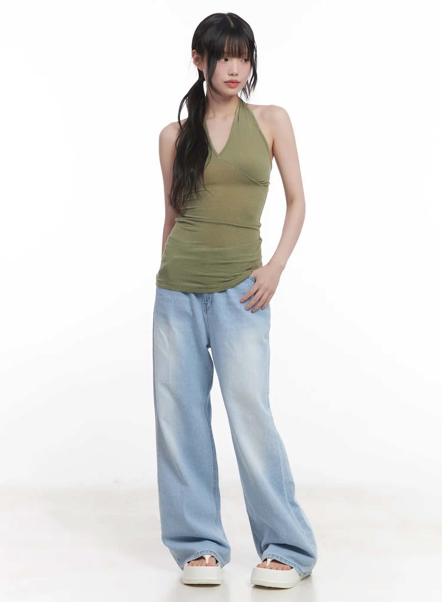Haerin Washed Wide-Leg Jeans CU519 in light blue, full-body slight-angle front shot on model, floor-grazing wide leg with washed fade, paired with olive halter top and white sandals.
