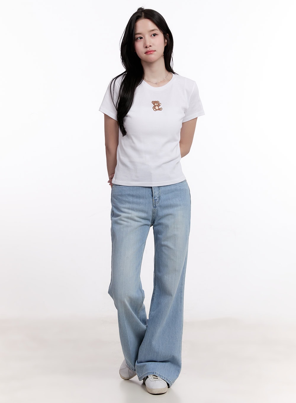 Daniella Relaxed-Fit Flared Jeans CM526 in light blue, full-body front-facing shot on model, relaxed high-waist washed denim flare, styled with fitted white tee and white sneakers.