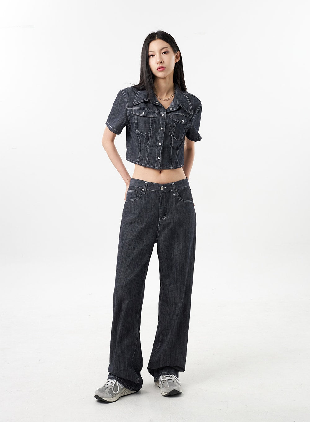 Low Rise Wide Pants CU312 in dark grey, full-length front view on model, relaxed wide-fit denim with white contrast stitching, styled in denim-on-denim set with crop jacket and sneakers.