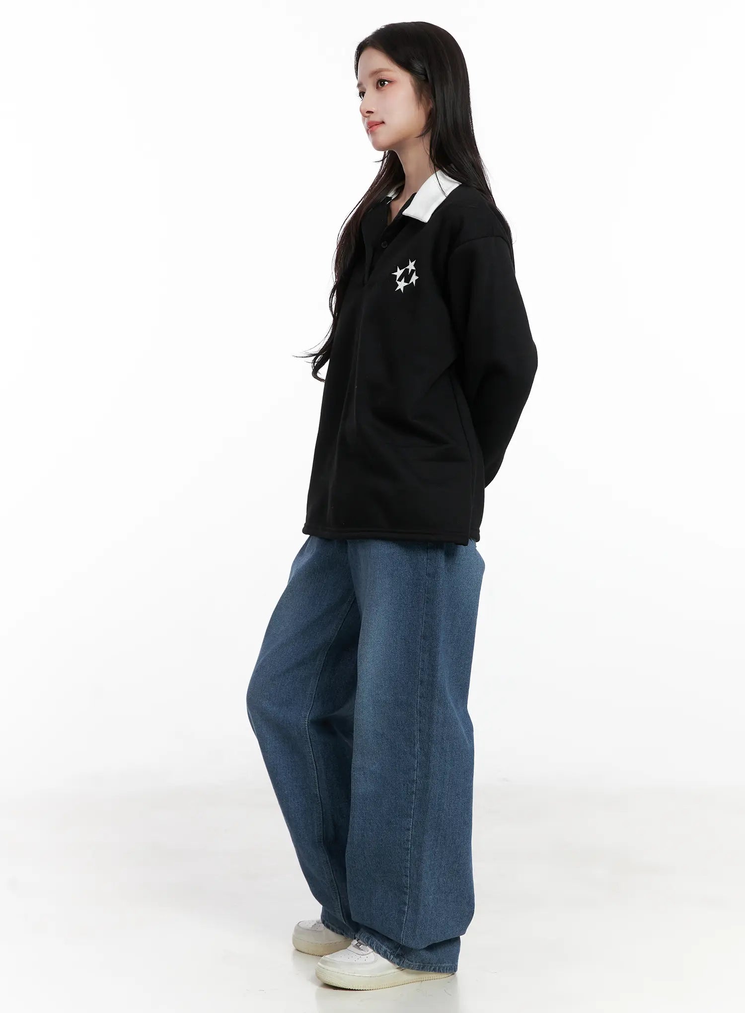 Mariam Baggy Jeans CN526 in blue, side angle on model, oversized wide-leg silhouette in washed cotton denim, paired with black star-print polo top and white sneakers.