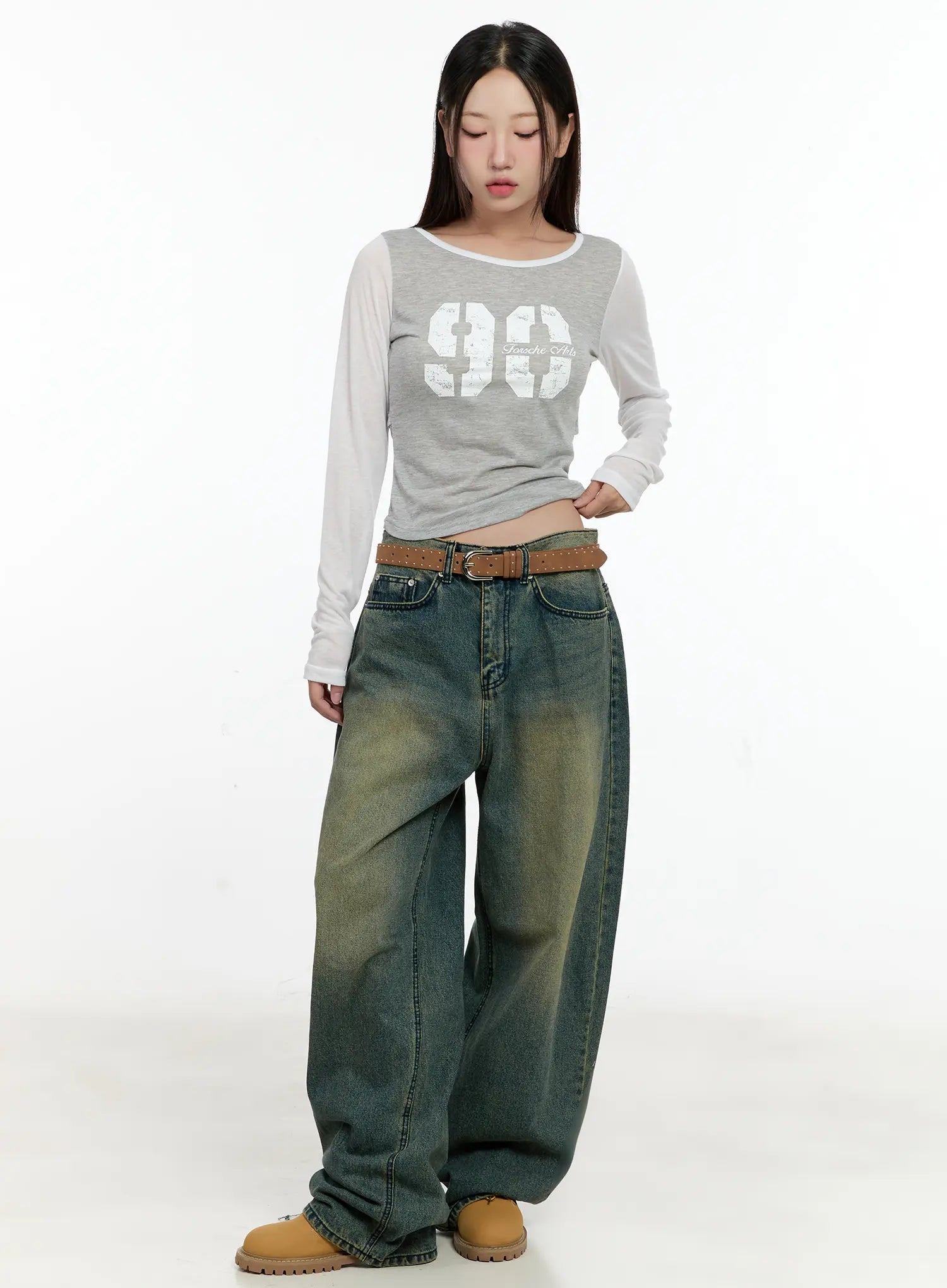 Sooyoung Baggy Vintage Wash Jeans CL531 in dark blue, full-body front on model looking down, baggy wide-leg fit with yellow-green wash gradient, belted, styled with crop top and tan boots.