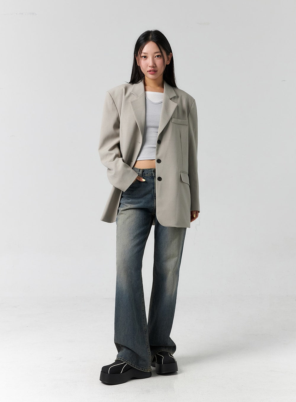 Vintage Wash Bootcut Jeans CS305 in blue, full-body front on model, relaxed normal fit with vintage-washed cotton denim, layered under a beige oversized blazer and white crop top.
