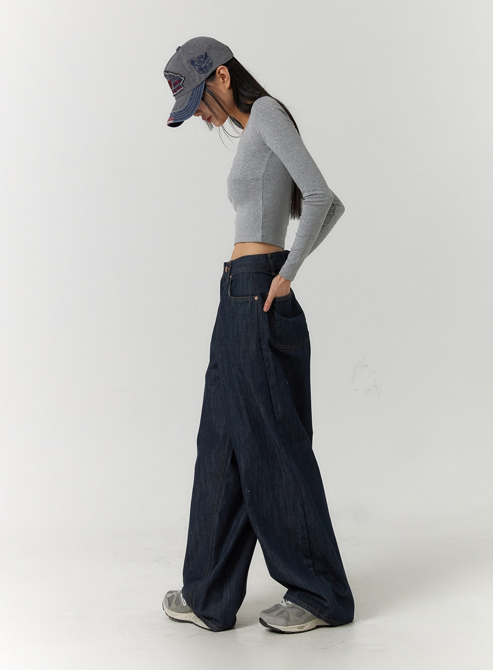 Back Button Wide Leg Jeans CF407 in blue, full-body side view on model looking down, extra-wide leg denim with voluminous silhouette, styled with grey crop top and sneakers.