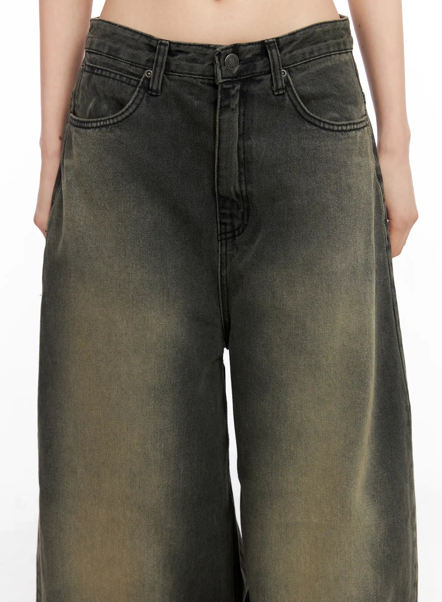 Elias Mega Wide Vintage Washed Jeans CC1109 in black, waist close-up on model, showing front pockets, button fly, and yellow-green vintage wash fading on wide-fit cotton denim.
