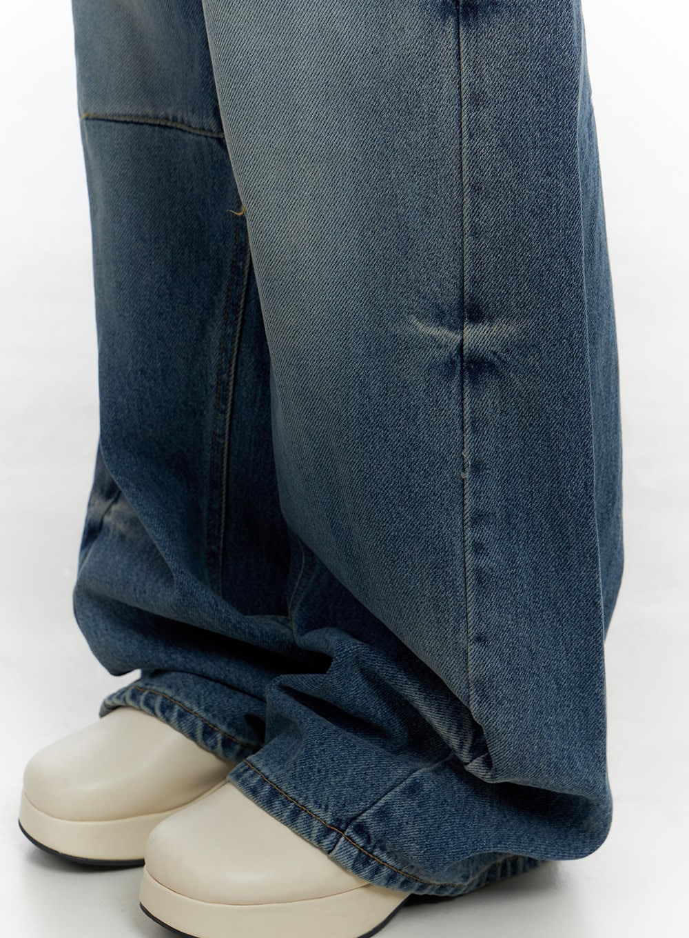 Aria Comfy Cotton Wide Leg Jeans CS420 in blue, lower-leg detail close-up, showing pintuck panel seam, washed denim texture, and voluminous hem bunching over cream platform shoes.