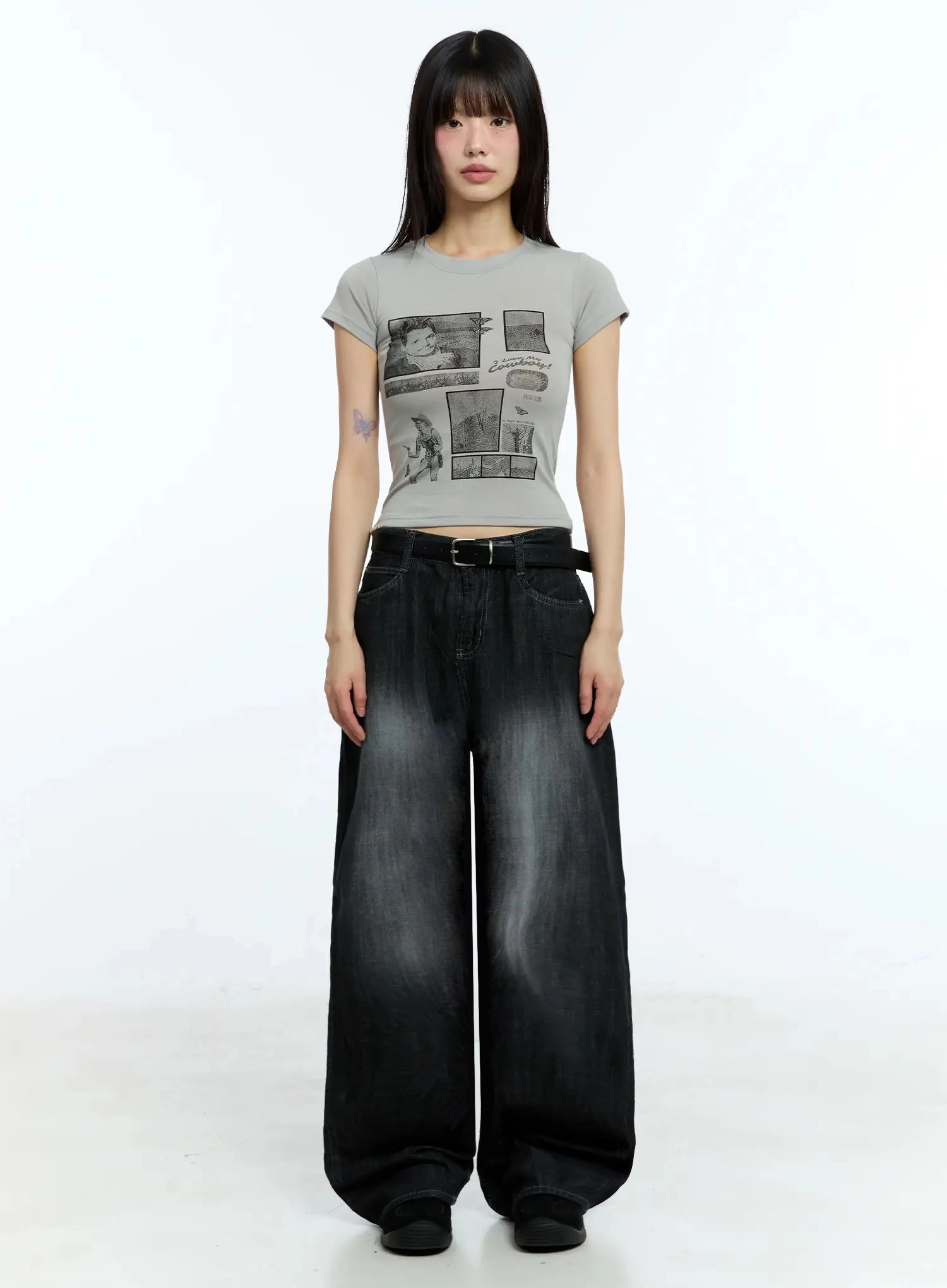 Wendy Washed Wide-Leg Jeans IU524 in black, full-body front shot on model, low-rise wide fit with washed fading, belted, styled with grey graphic crop tee and flat shoes.
