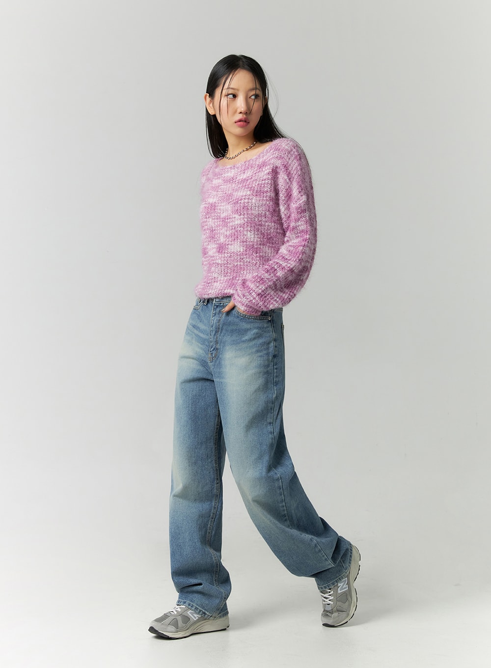 Straight Fit Jeans CN324 in blue, front three-quarter angle on model mid-stride, wide-leg washed denim showing leg drape, styled with pink knit and grey New Balance sneakers.