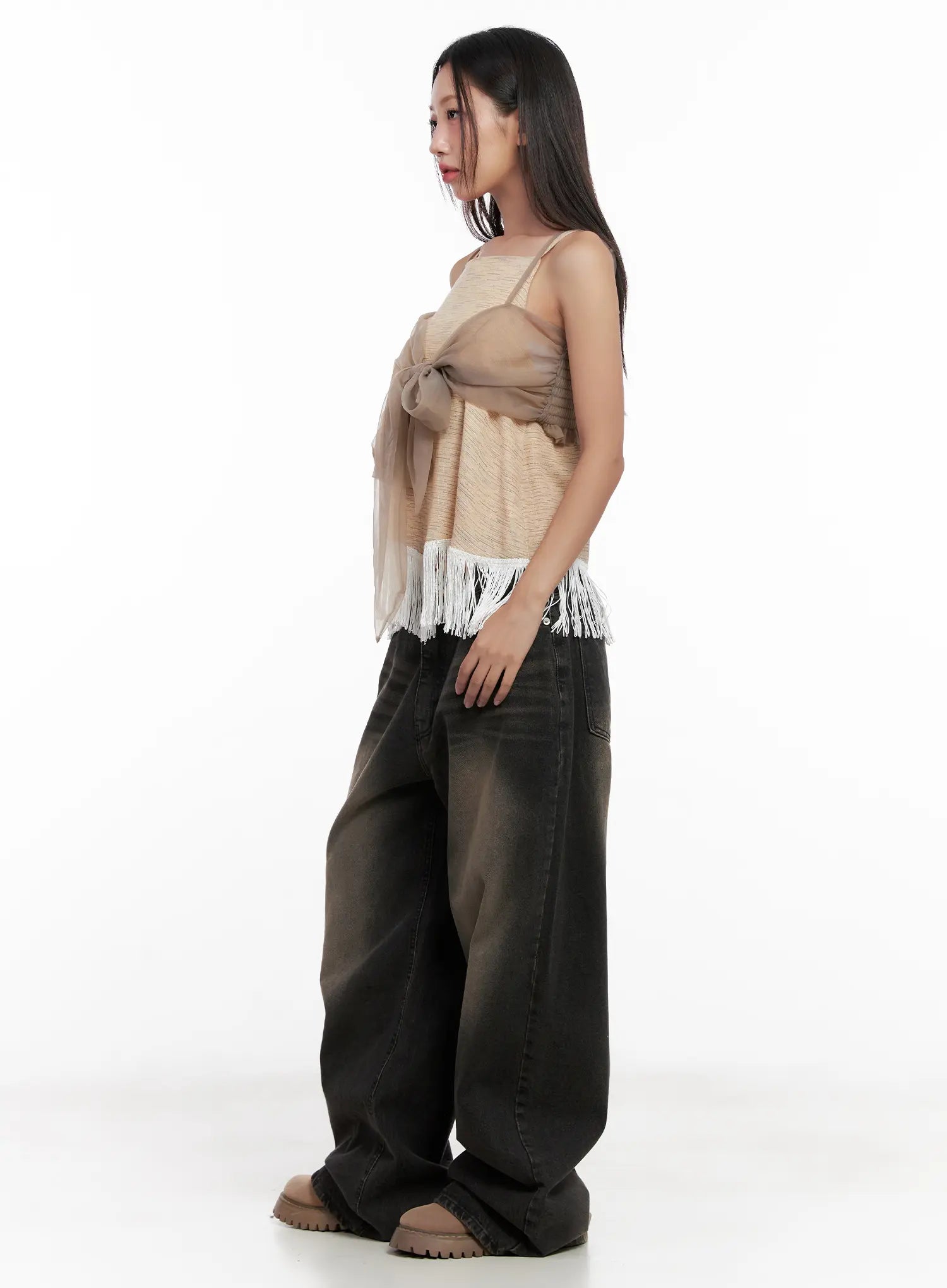 Ari Washed Wide-Leg Denim Jeans CL521 in Black, side full-body shot on model, wide-leg silhouette with brown-tone washed fade, paired with fringe cami top and chunky sandals.