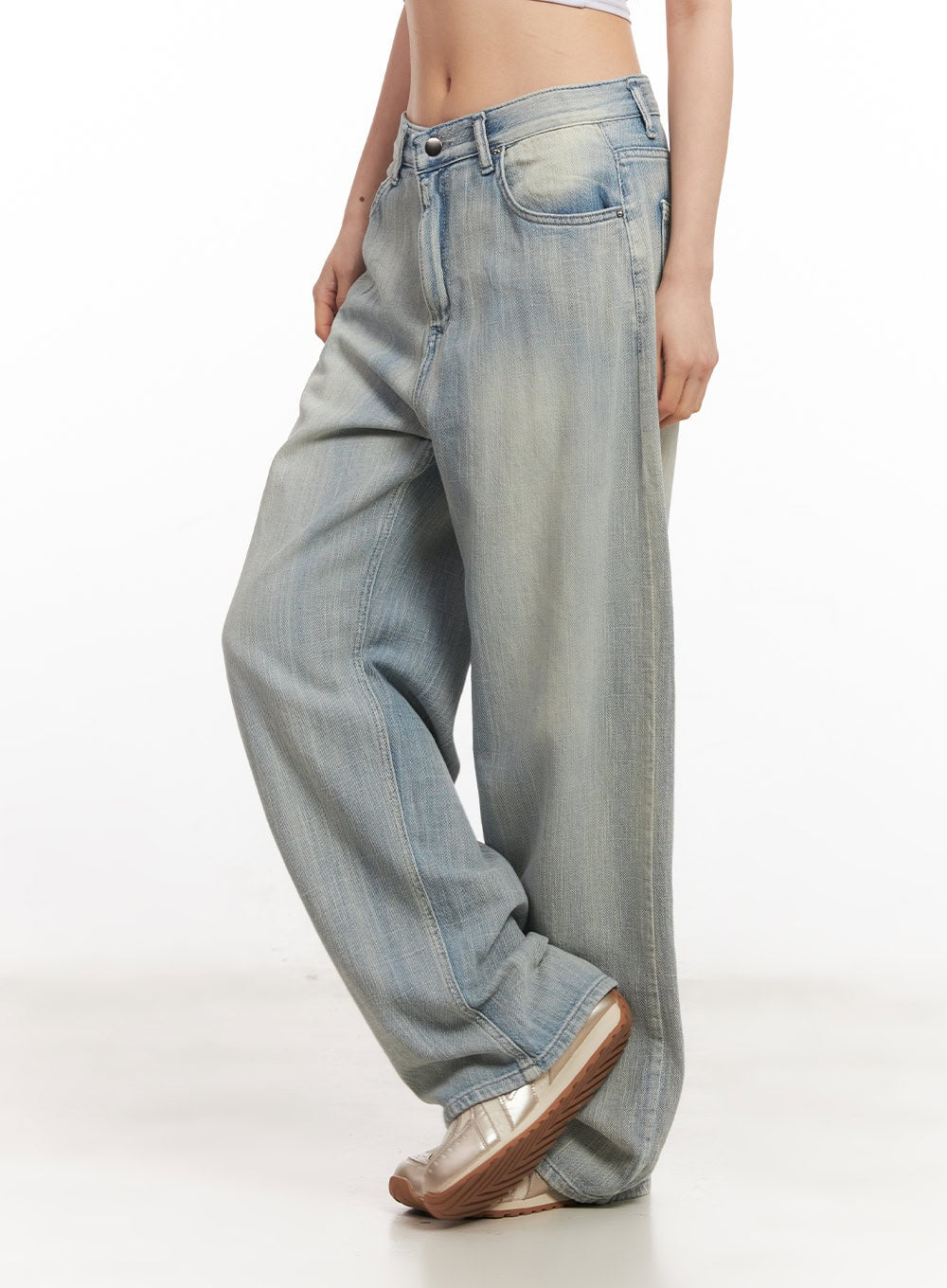 Jessi Washed Wide-Leg Jeans CA514 in light blue, side view on model, low-rise wide-leg silhouette with sun-faded washed denim and floor-grazing hem, paired with metallic sneakers.