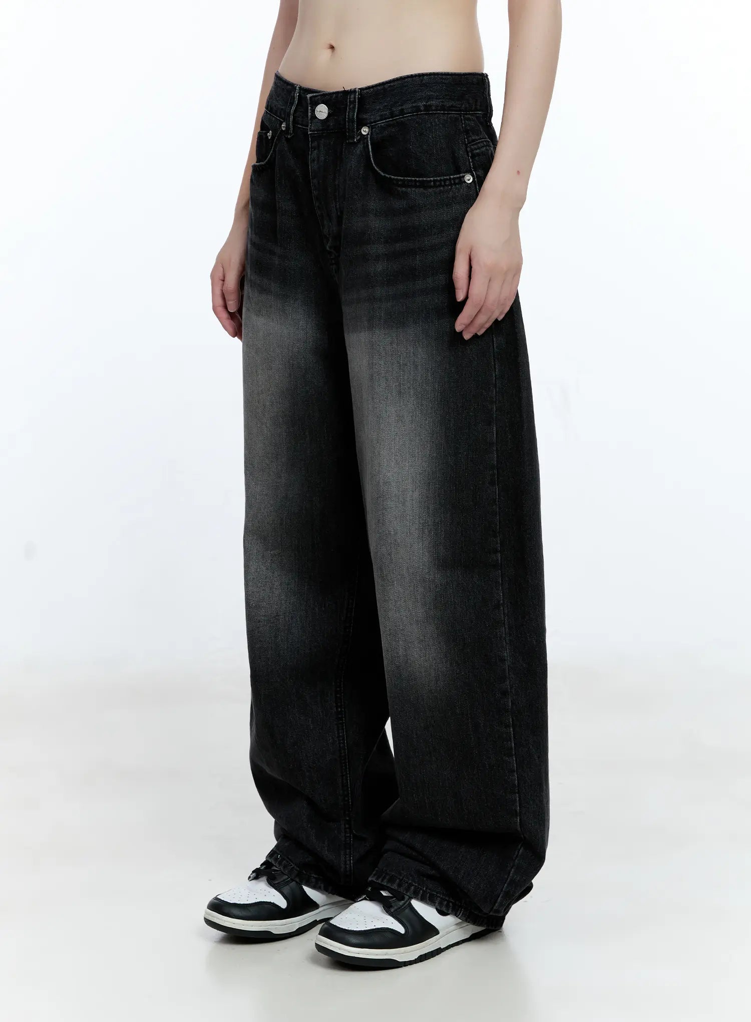 Gayeon Washed Wide-Leg Jeans CG507 in black, close-up front view on model, showing washed fading detail, front pockets and low-rise waistband with button closure.