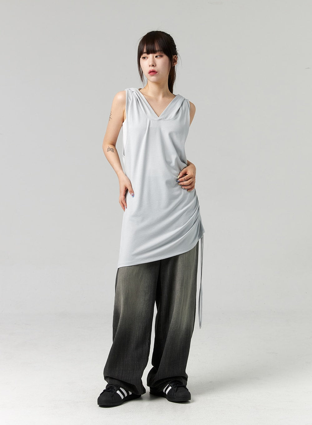Baggy Jeans CL321 in washed dark grey, full-body front view on model with relaxed arms, wide-leg washed denim paired with grey sleeveless hooded top and black sneakers.