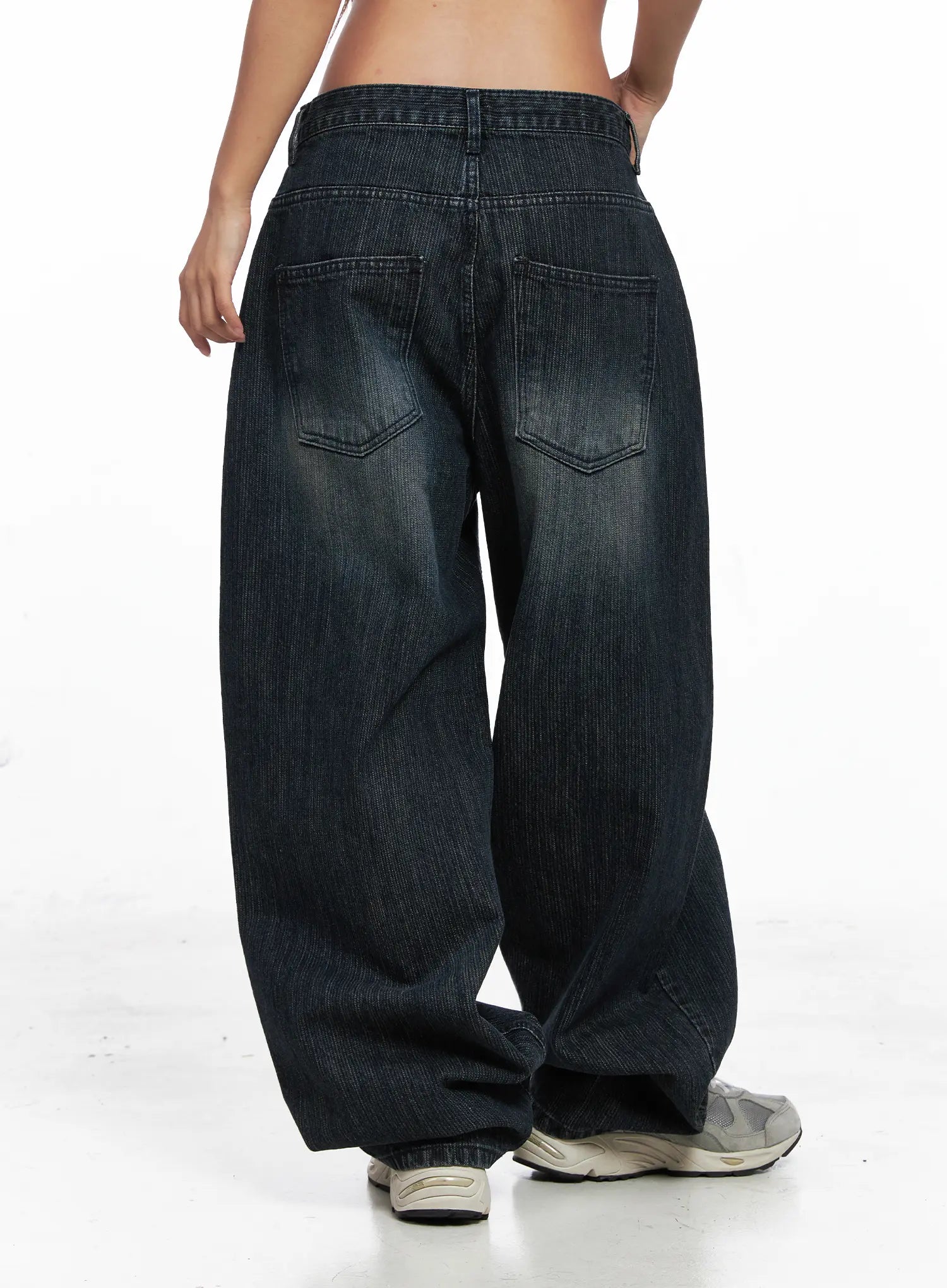 Aspyn Wide-Leg Washed Corduroy Jeans CO510 in dark blue, back view on model, dual back pockets with stitching detail, washed corduroy wide-leg cotton, low-rise waistband.