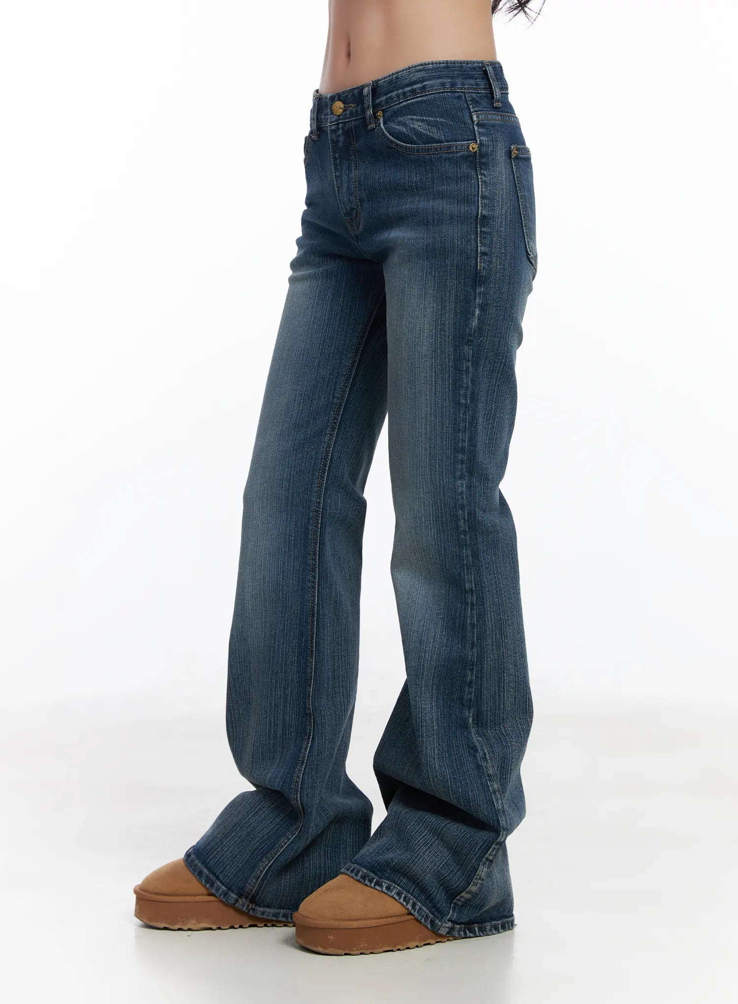 Astrid Low Rise Flared Bootcut Jeans CJ514 in blue, side view on model, low-rise fit showing flared bootcut silhouette, washed denim with vertical stitch lines, worn with tan platform shoes.