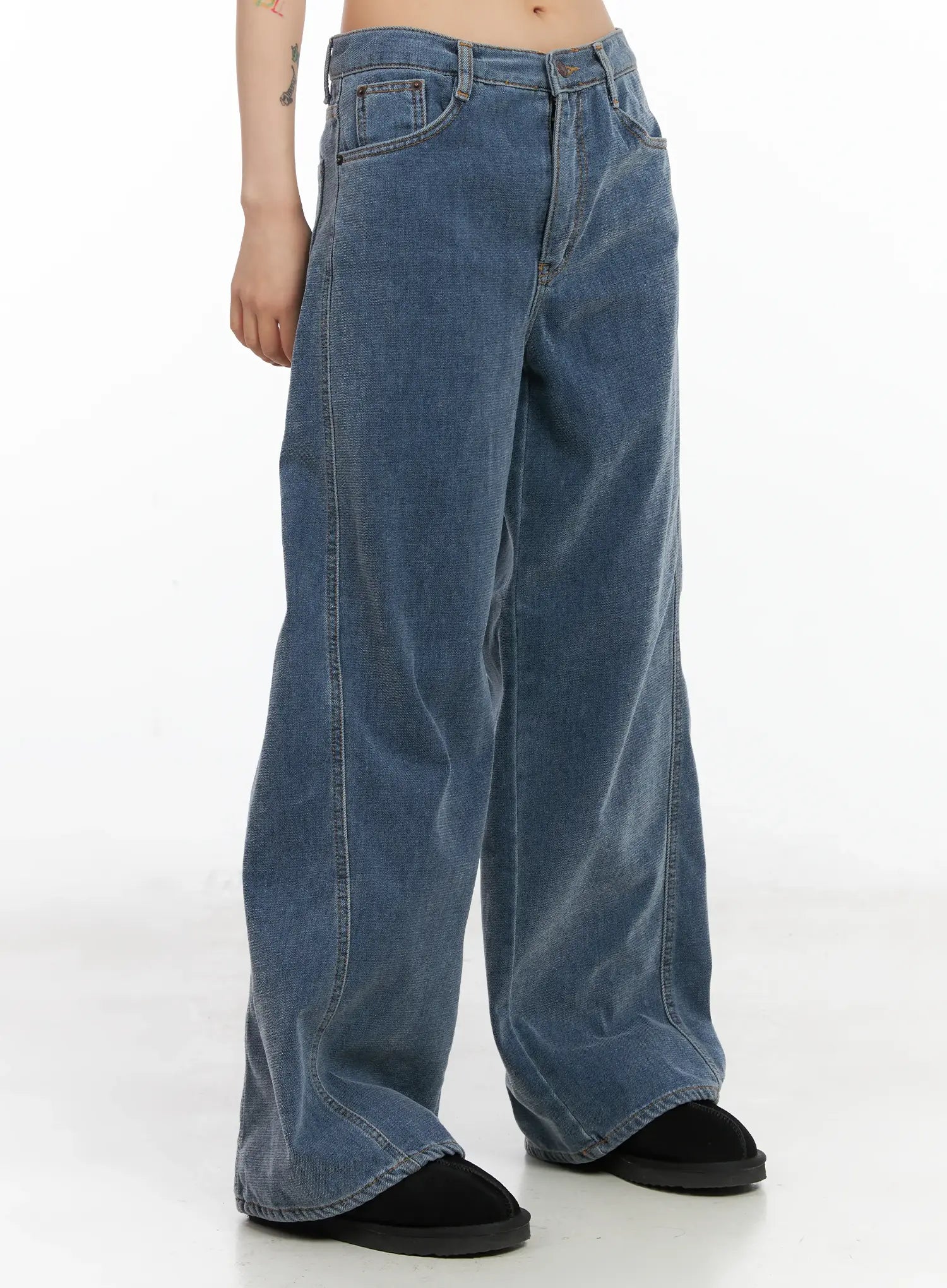 Norah Oversized Jeans CN528 in blue, three-quarter side view on model, washed wide-fit denim with curved hem pooling at ankle, casual street style.