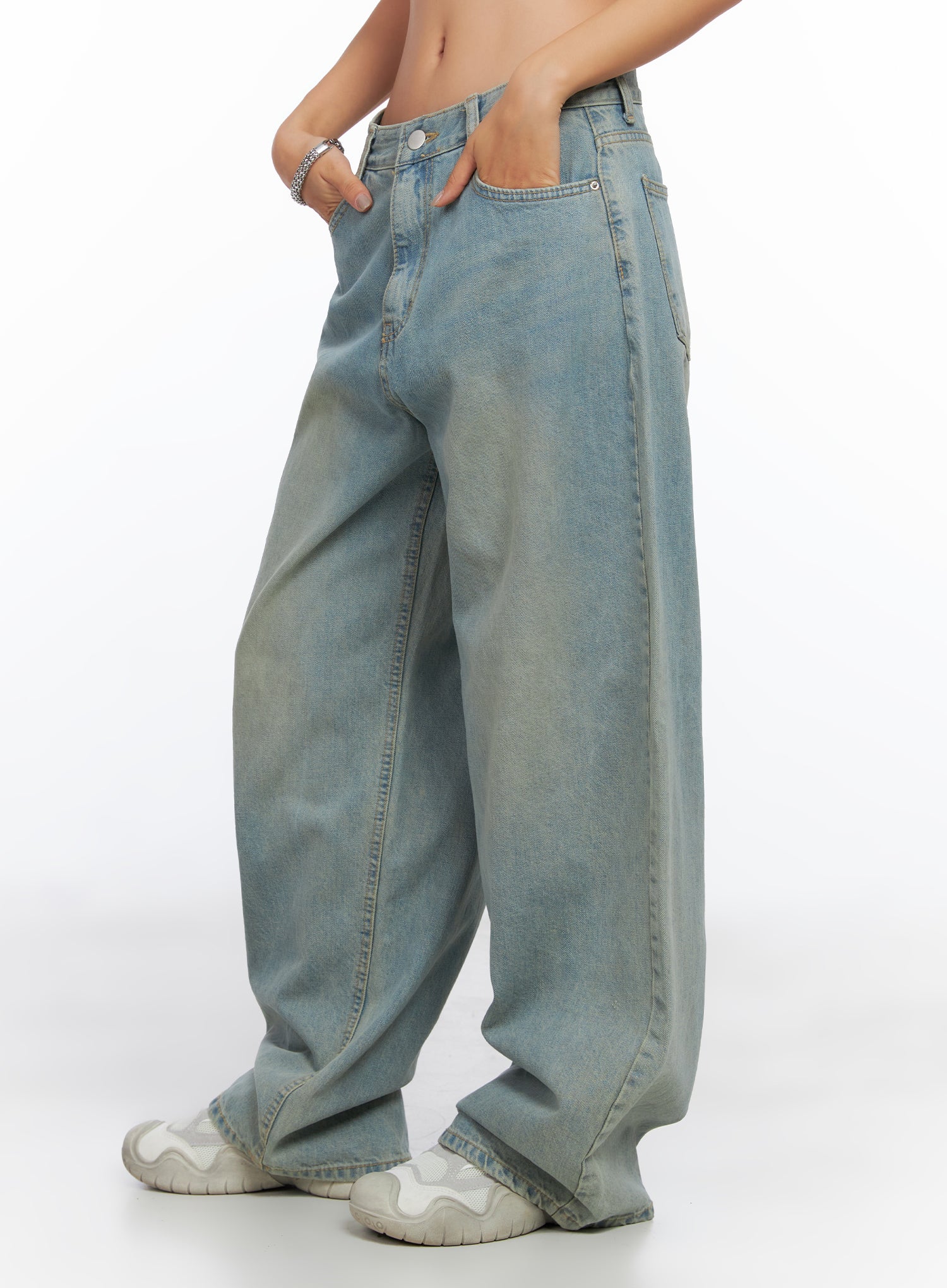 Remi Washed Baggy Jeans CO515 in light blue, side view on model, hands in pockets, ultra-wide baggy leg with sun-faded washed cotton, paired with white sneakers.