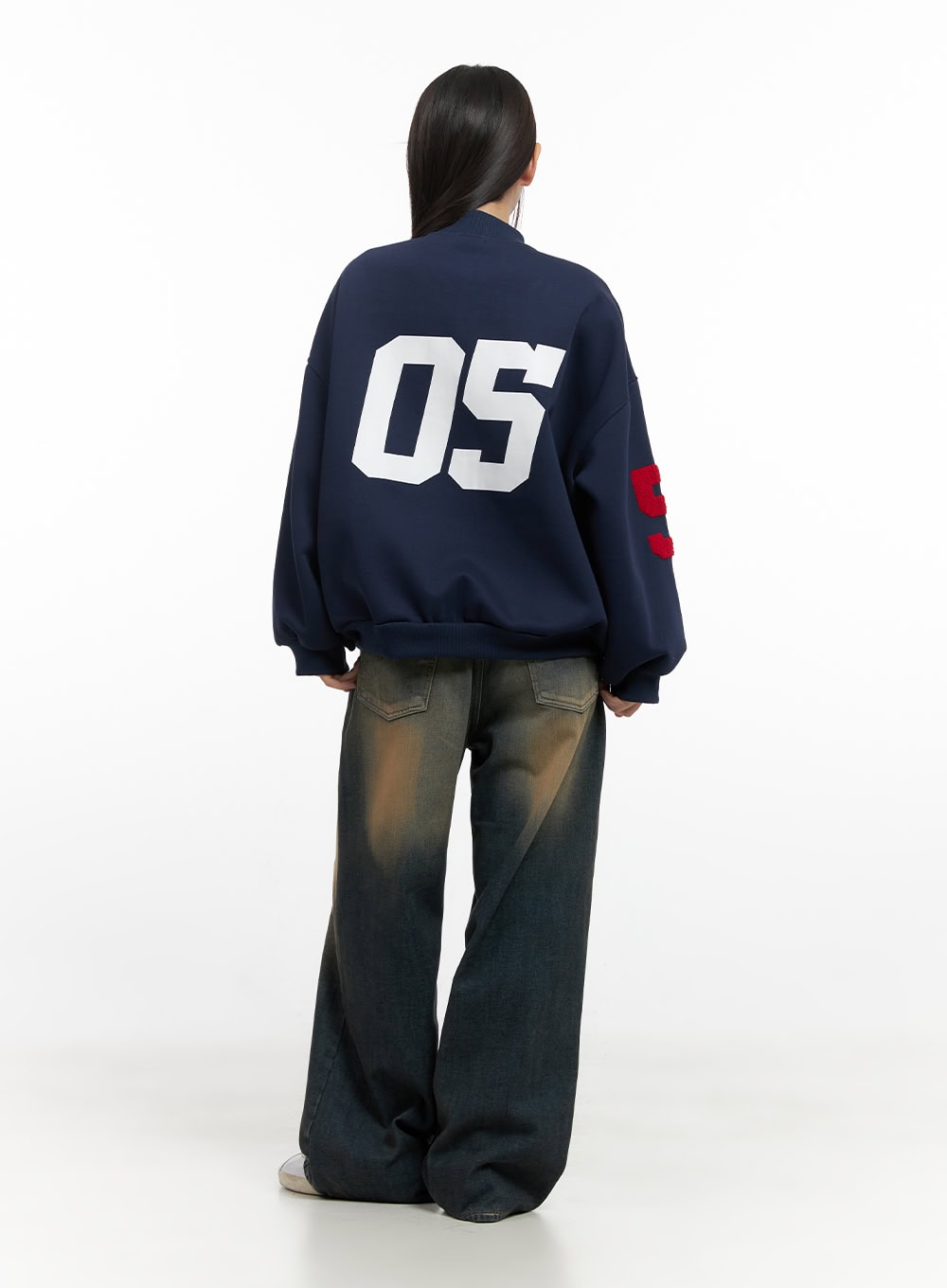 Bryana Cotton Comfort Wide Leg Jeans CN419 in dark blue, back full-body shot on model, vintage washed cotton denim with amber fade, wide leg with floor-grazing hem, paired with navy varsity jacket.