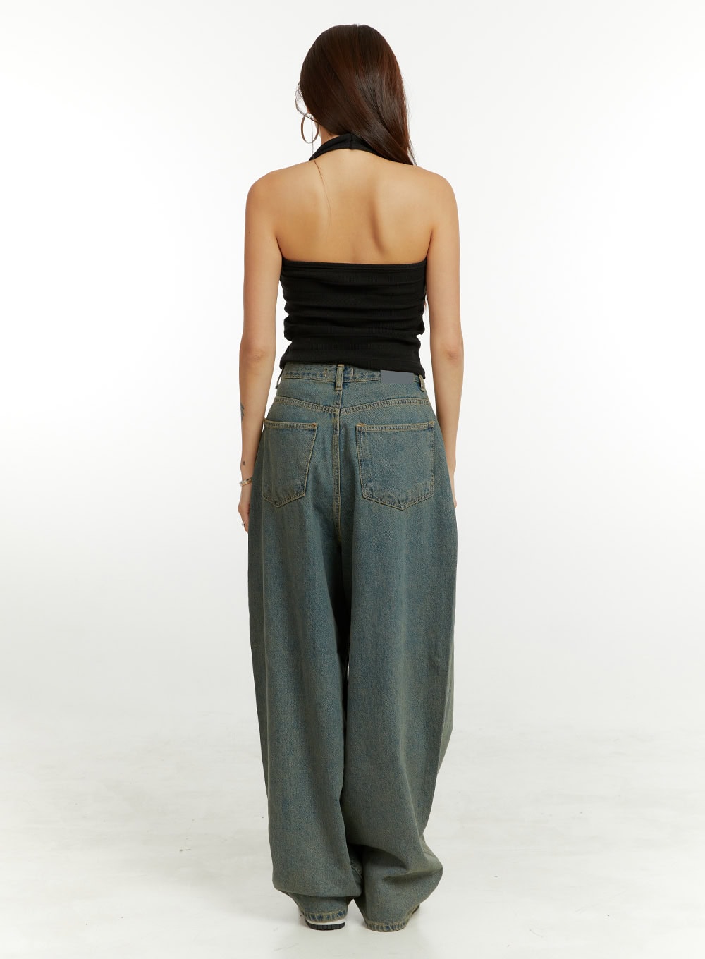 Denim Washed Baggy Jeans CU424 in blue, full-length back view on model, featuring two rear pockets and exaggerated baggy fit in washed cotton denim, with black halter top.