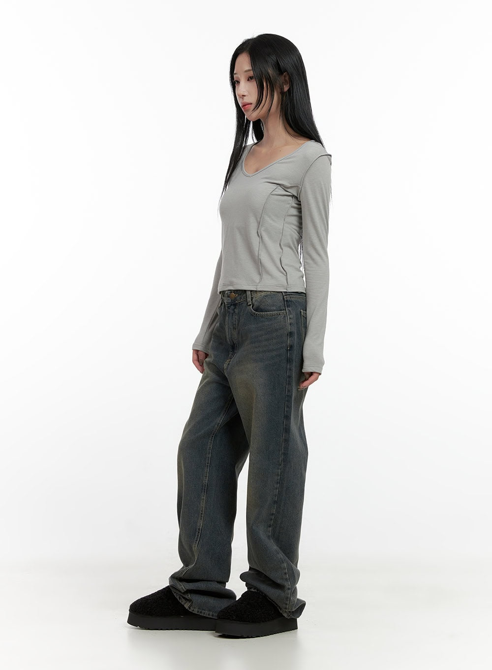 Alina Washed Wide-Leg Jeans CN407 in blue, three-quarter side view on model, relaxed wide fit with yellow-toned washed denim, styled with grey cropped top.