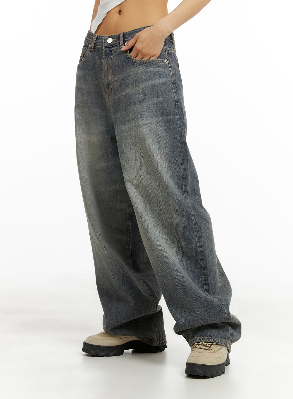 Vintage Washed Baggy Jeans CA424 in blue, side close-up from waist to hem on model, baggy wide-leg denim with gradient washed finish, hand in front pocket, chunky sole sneakers.