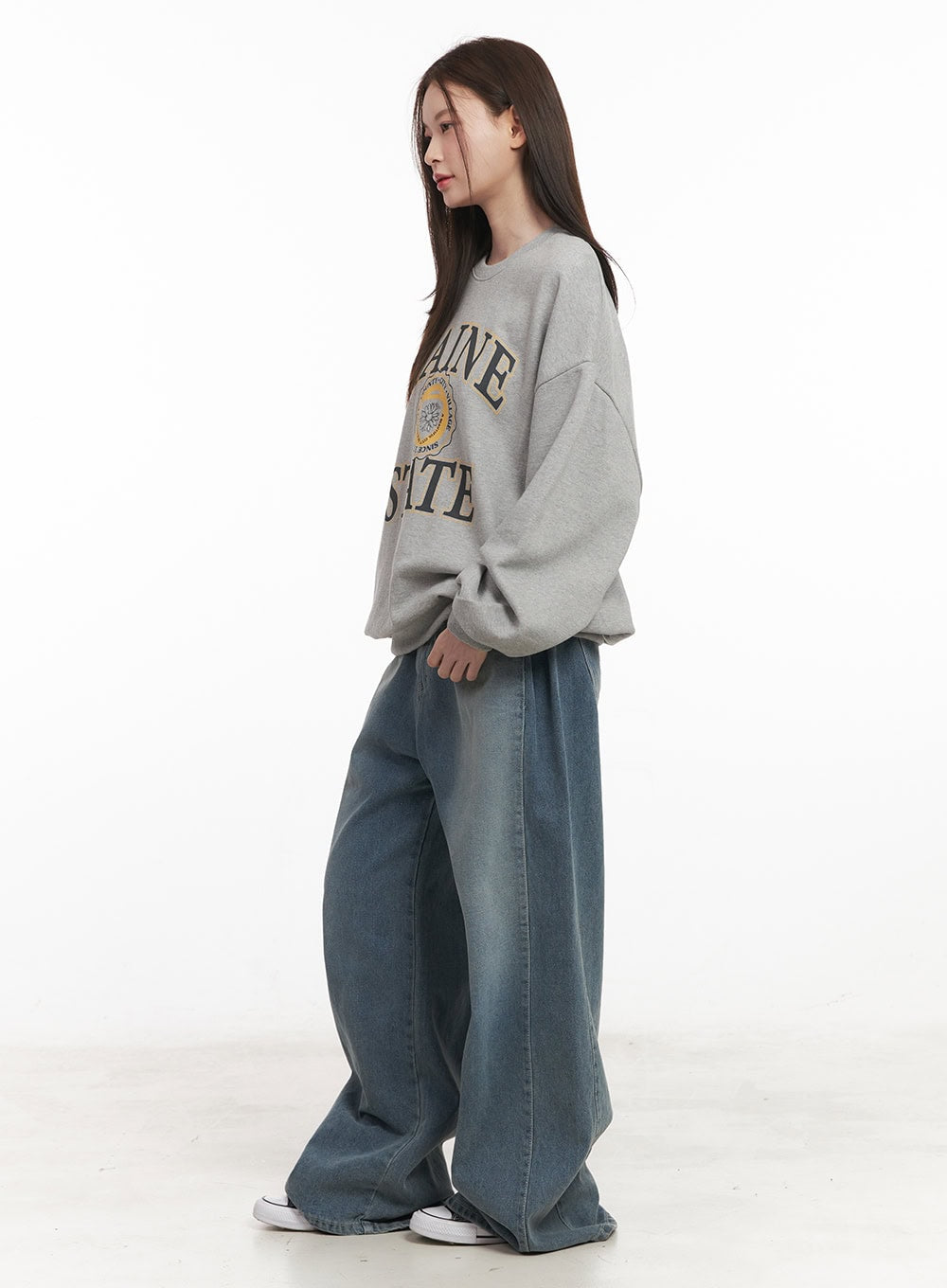 Amber Pintuck Wide-Leg Jeans CM511 in blue, side full-body shot on model, wide-leg washed denim showing pintuck line, styled with grey sweatshirt and sneakers.