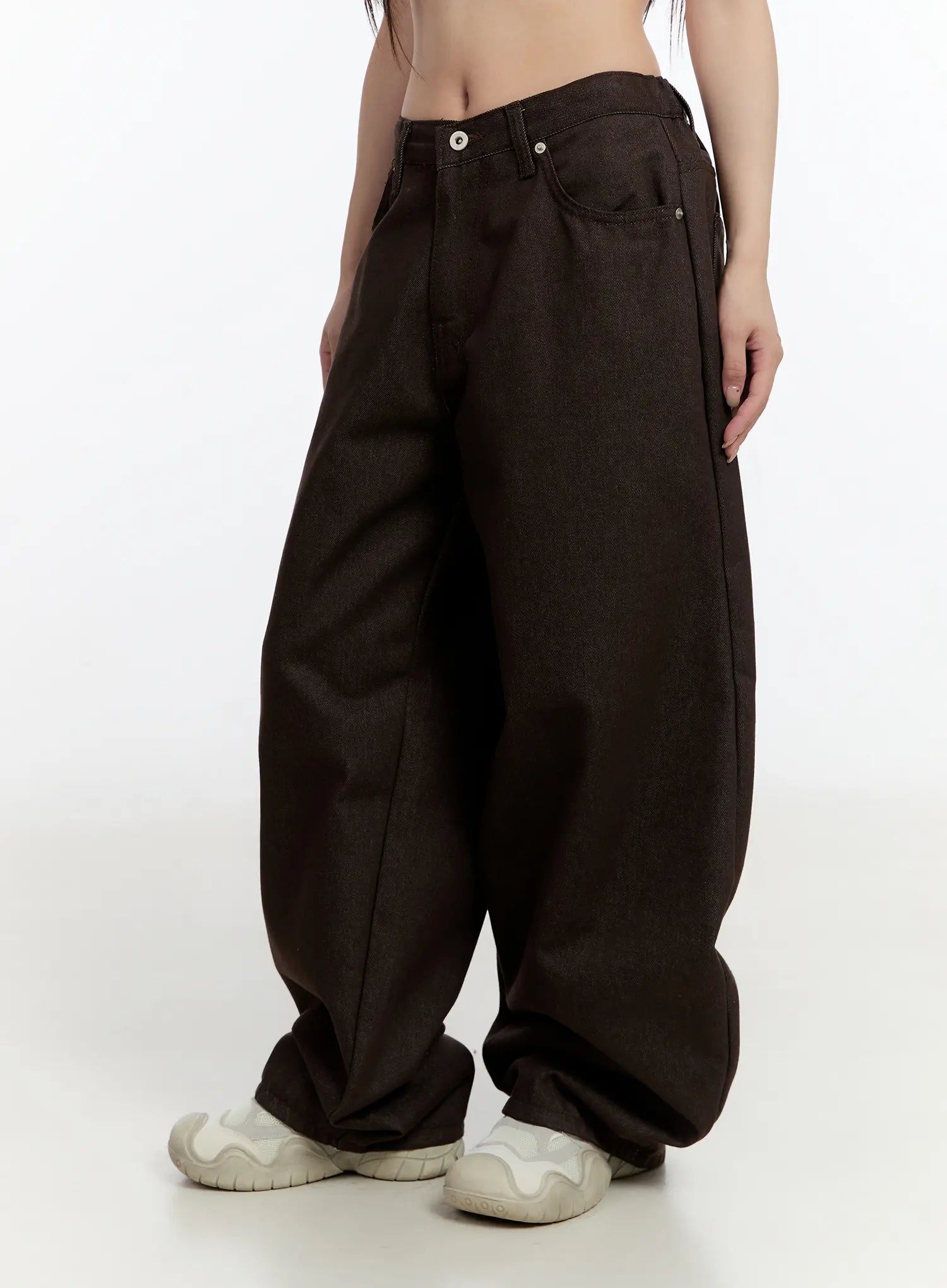 Emely Wide Leg Jeans CN524 in dark brown, side close-up on model, low-rise waistband with button fly, exaggerated wide leg cotton-polyester denim, styled with white sneakers.