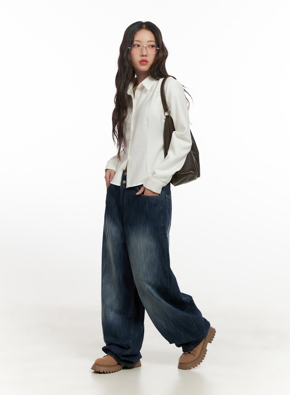 Jessica Wide-Fit Denim Jeans CN426 in blue, full-body angled shot on model, hands in pockets, worn with white shirt and brown shoulder bag, baggy street-style silhouette.