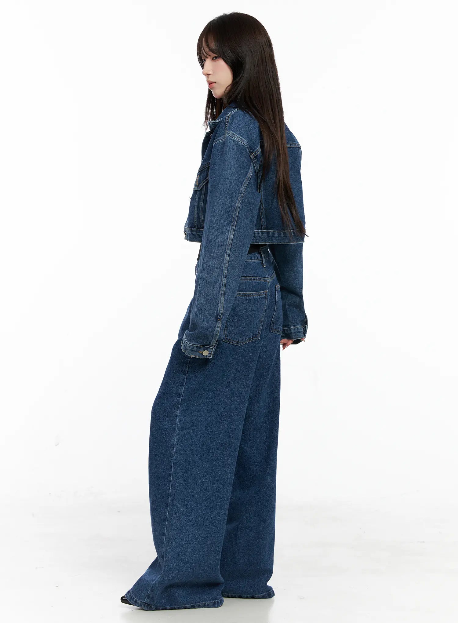 Eliza Seam Detail Relaxed Bootcut Jeans CO521 in washed blue, side full-length on model, paired with cropped denim jacket, seam detail visible along leg, wide bootcut hem pooling at floor.