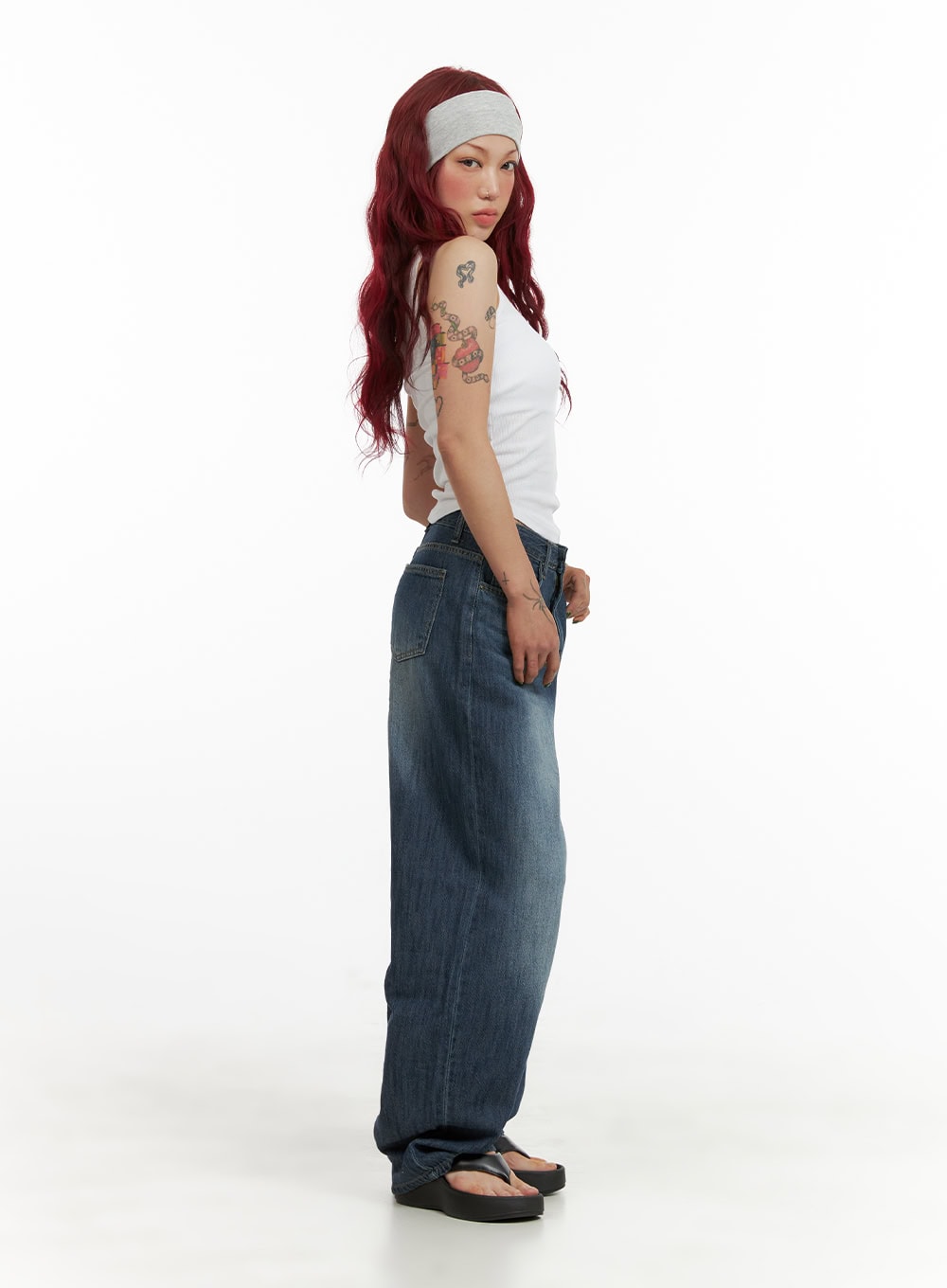 Wide Fit Baggy Jeans CY430 in dark blue, three-quarter side full-body shot on model, washed baggy denim with exaggerated wide leg, styled with white tank and gray headband.