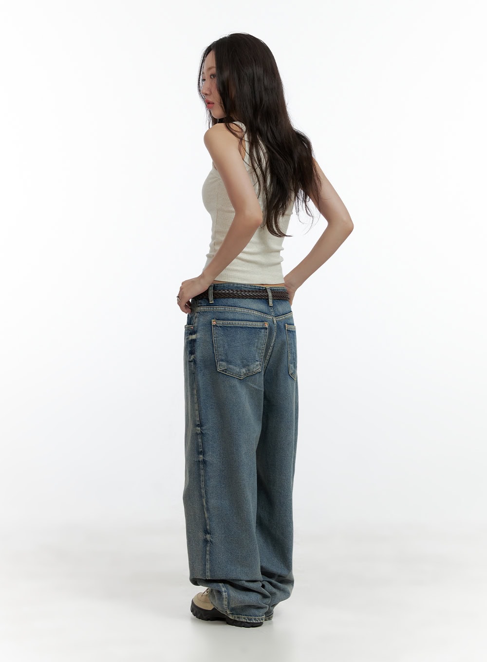 Dark Washed Baggy Jeans CL410 in blue, back three-quarter full-length shot on model, low-waist baggy denim with back patch pockets and washed finish, paired with cream tank top.