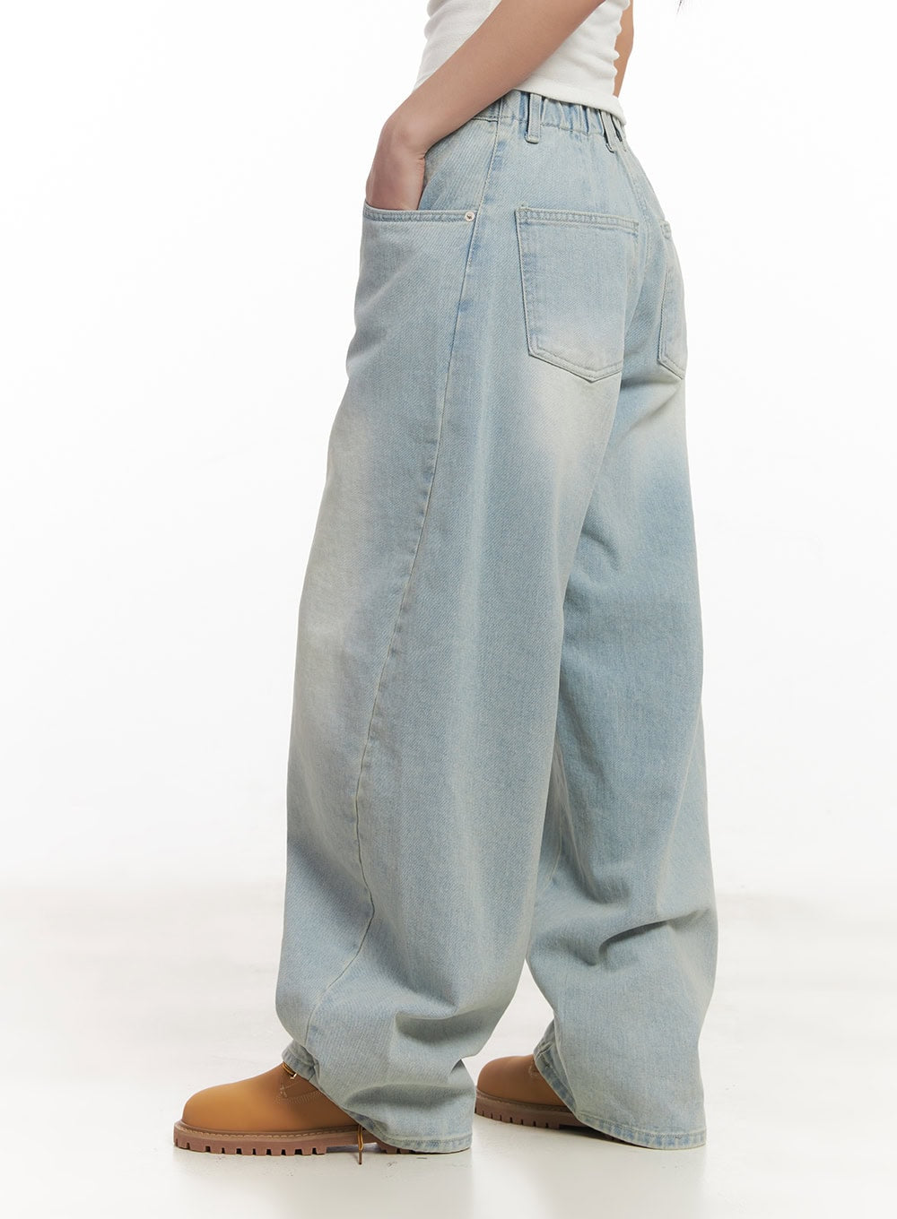 Alia Washed Wide-Leg Jeans CA518 in light blue, rear three-quarter side view on model, highlighting back pocket placement, washed denim texture, and oversized balloon-leg shape.