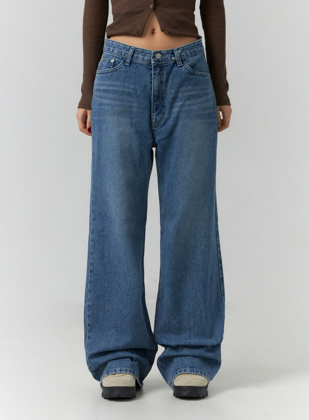 Wide Leg Jeans J12 in blue, waist-to-hem front close-up on model, gradation wash cotton denim, wide leg silhouette, front pockets and button fly detail visible, paired with chunky sneakers.