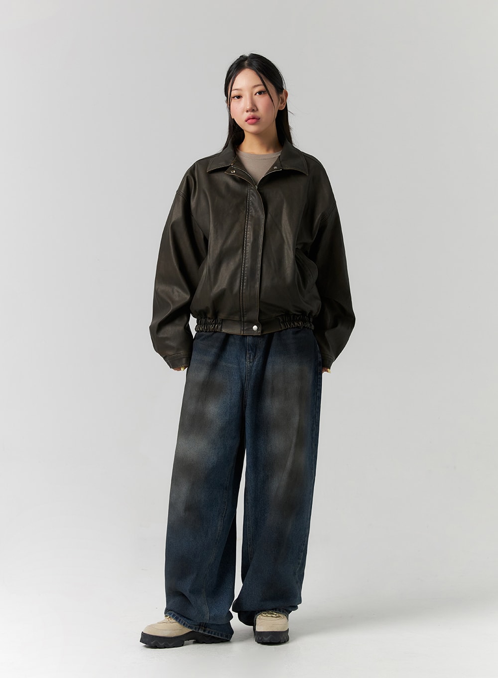 Tie-Dye Washed Wide Leg Jeans CS320 in dark blue, full-body slight three-quarter view on model, tie-dye washed wide leg denim paired with dark leather bomber and cropped tee.