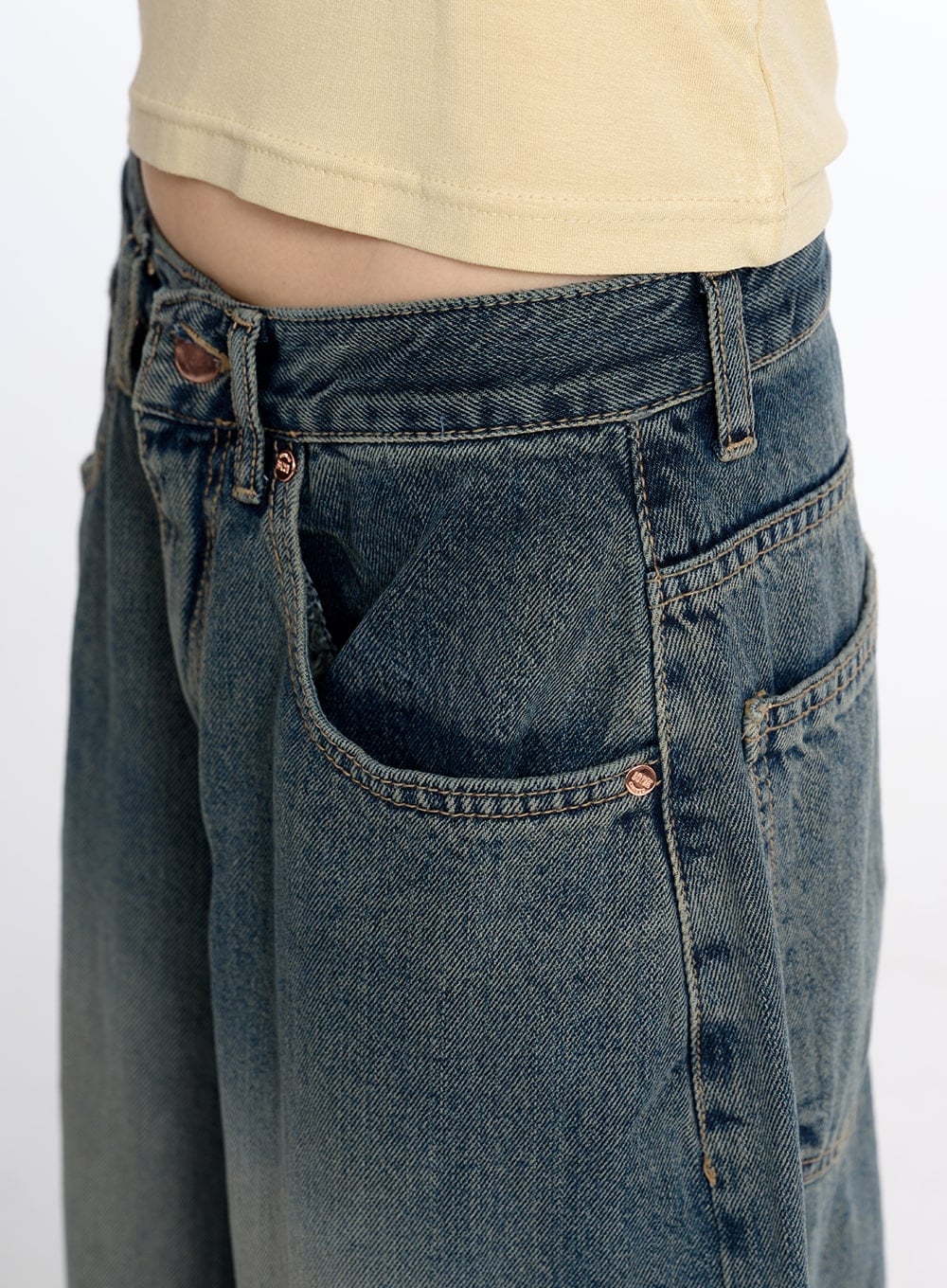 Vintage Low Rise Baggy Jeans CM415 in dark blue, close-up detail of front waistband and pocket area, showing low-rise cut, copper rivets, and vintage-washed cotton denim texture.