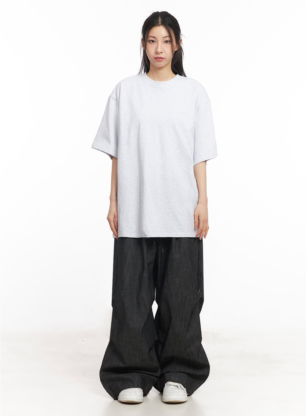 Pintuck Denim Sweatpants IY529 in black, full-length front view on model, relaxed wide-fit denim with pintuck detail and banded waist, styled with oversized grey tee and white sneakers.