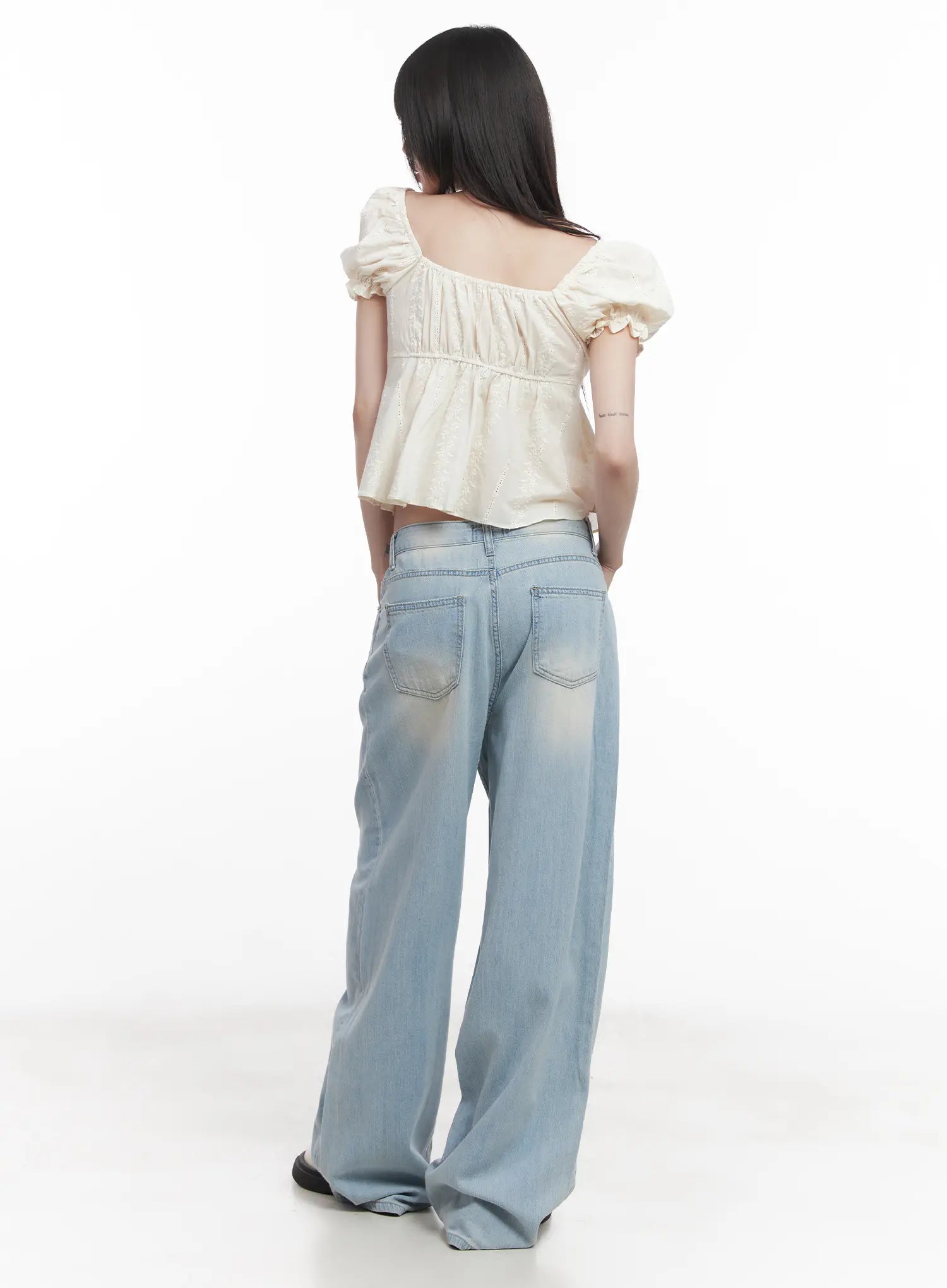 Garam Washed Wide-Leg Jeans CU518 in light blue, back view on model, large patch pockets with contrast stitching, washed denim, paired with cream puff-sleeve top.