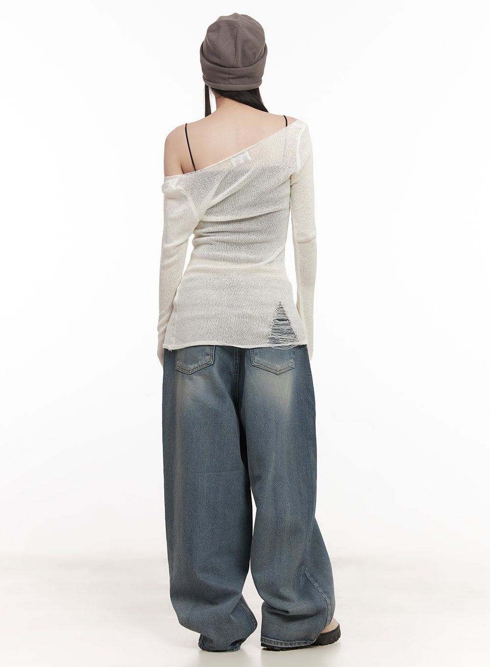 Shelly Washed Baggy Jeans CM518 in blue, rear close-up on model, back pockets with washed fading detail and extra-wide baggy leg silhouette, paired with distressed knit top.