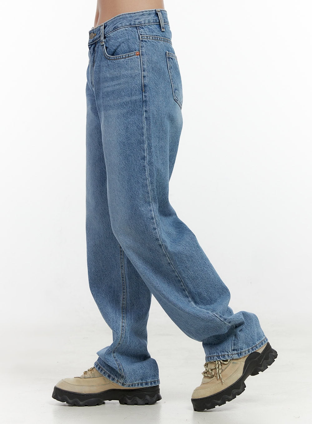Carly Cloud Wide-Leg Jeans ON404 in blue, side close-up on model, wide-fit washed denim showing roomy leg opening and stitched seam detail, worn with chunky sneakers.