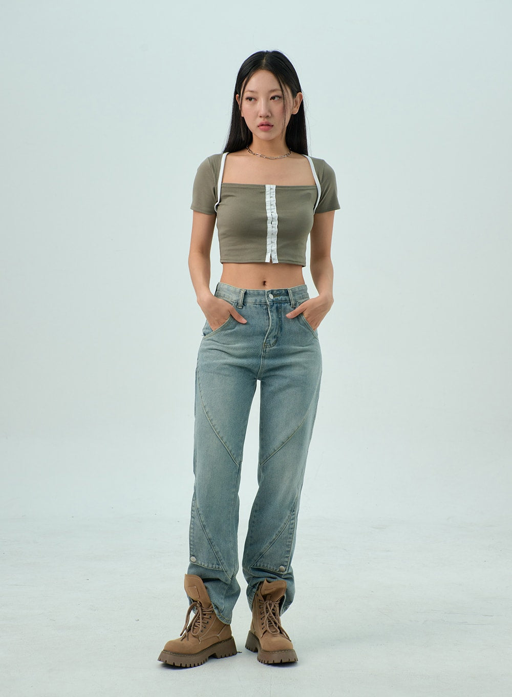 Straight Leg Jeans CY330 in light blue wash, full-length front shot on model with hands in pockets, geometric panel seams visible on leg, paired with olive crop top and tan boots.
