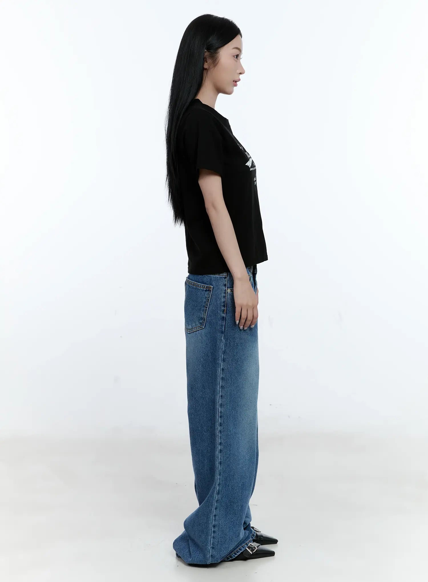 Dahye Washed Relaxed-Fit Denim Jeans CL530 in blue, full-length side profile on model, wide-leg silhouette floor-grazing hem, back pocket visible, styled with black crop tee and heels.