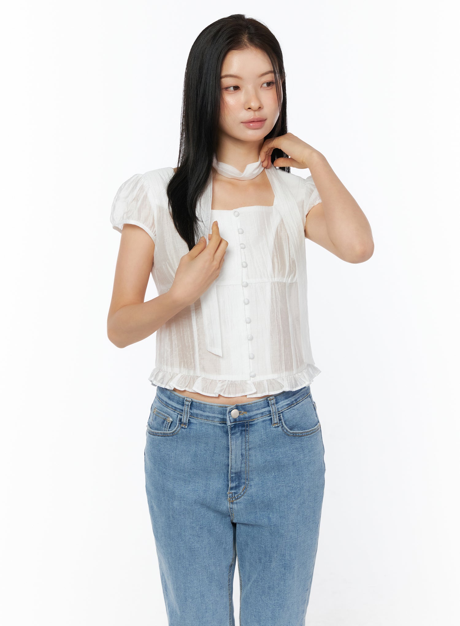 Puff Sleeve Shirred Blouse with Scarf IU519 in white, front close-up on model adjusting scarf, square neckline and button-front detail highlighted, sheer fabric with shirring, paired with blue jeans.