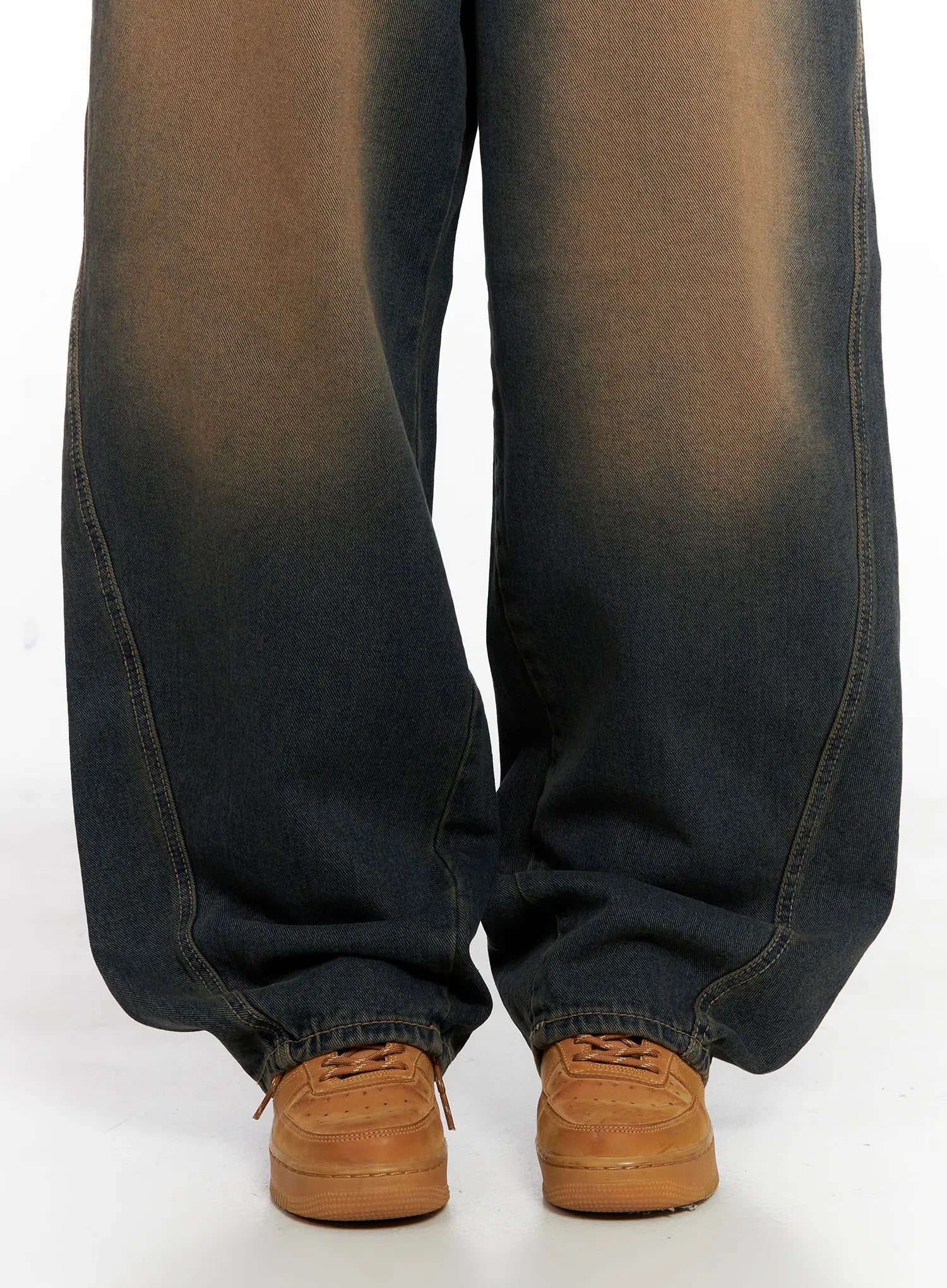 Jaycee Vintage Wash Baggy Jeans CG519 in dark blue, lower-leg close-up on model, highlighting wide pooling hem, brown-to-dark fade wash, and voluminous silhouette over tan sneakers.