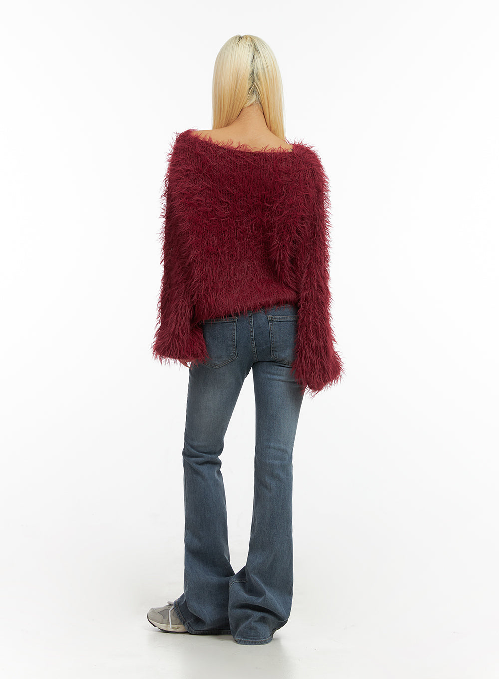 Liv Washed Denim Low Waist Bootcut Jeans CO414 in blue, back full-body view on model, back pockets and flared bootcut hem shown, washed denim, styled with red shaggy top and sneakers.